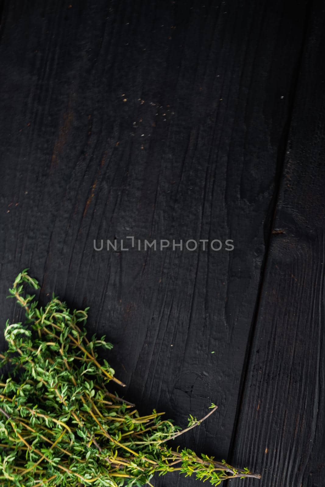 Thyme green fresh bunch, on black wooden table, top view with copy space for text