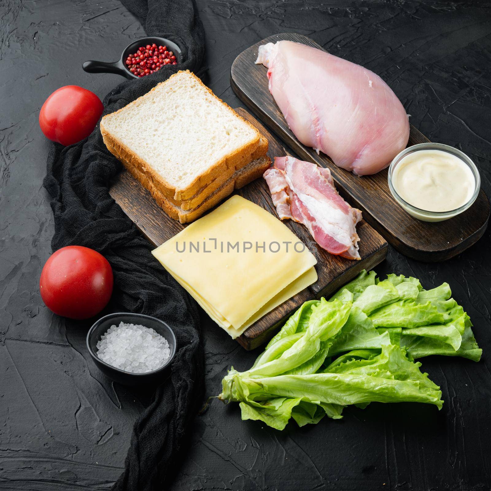 Fresh ingredients for tasty sandwich, on black background by Ilianesolenyi