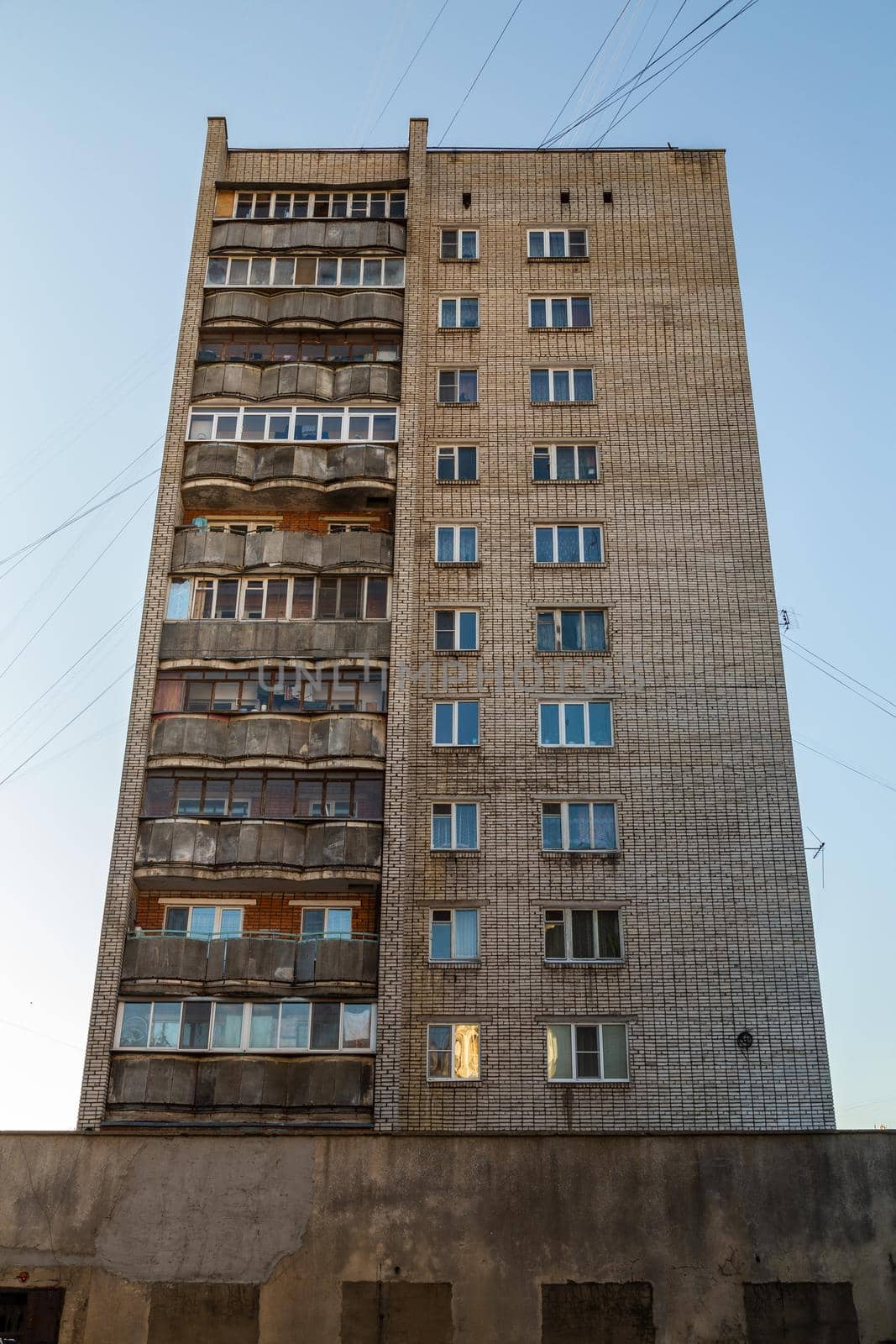 typical mid-russian silicate brick high rise condominium residential building, upward view on blue sky background