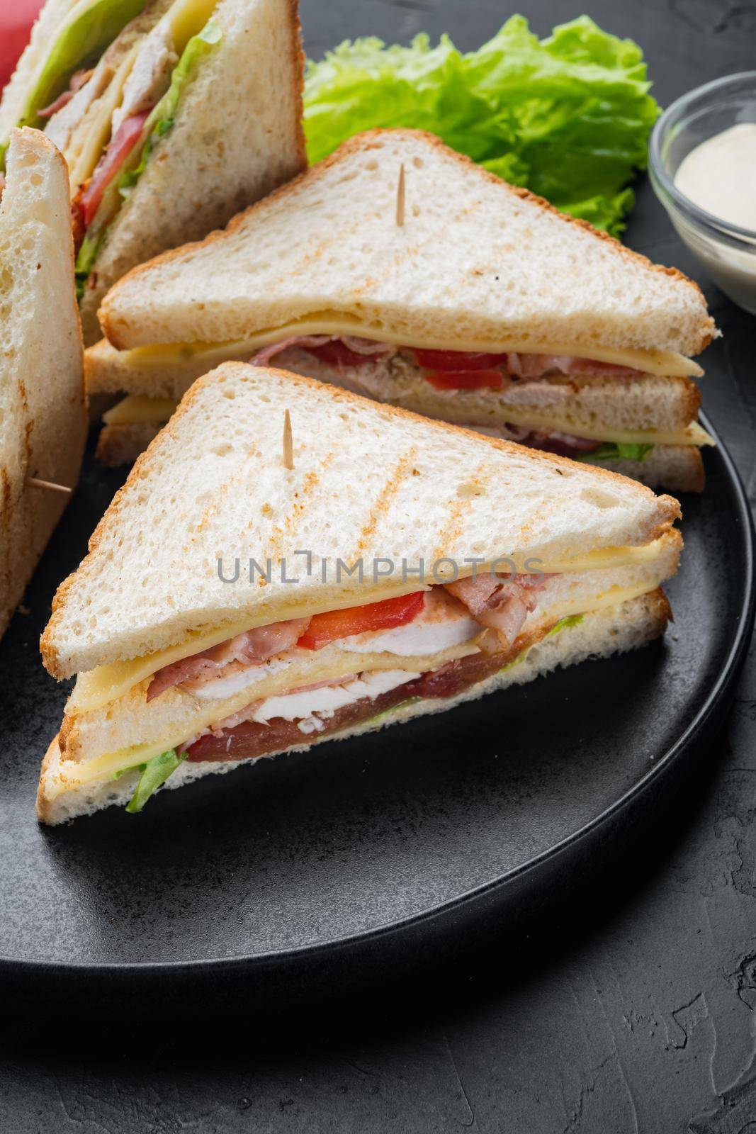 Homemade chicken sandwich halves, on black background