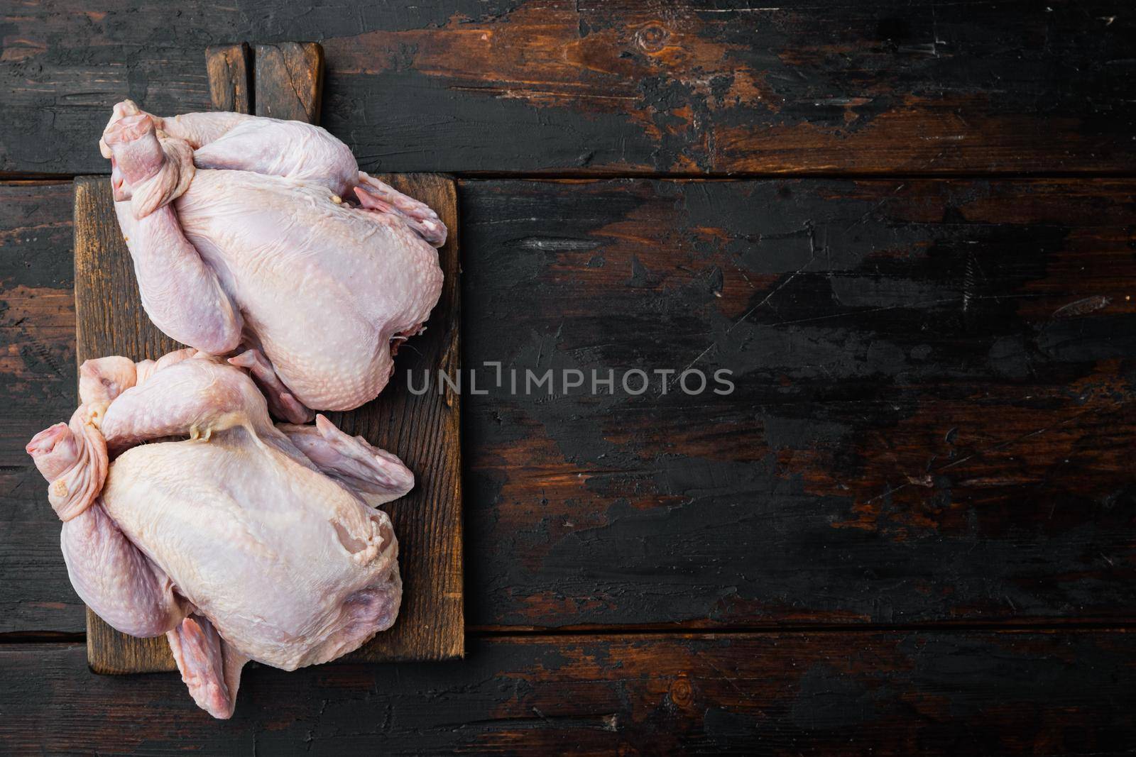 Raw organic uncooked whole chicken meat, on old wooden table, top view with copy space for text