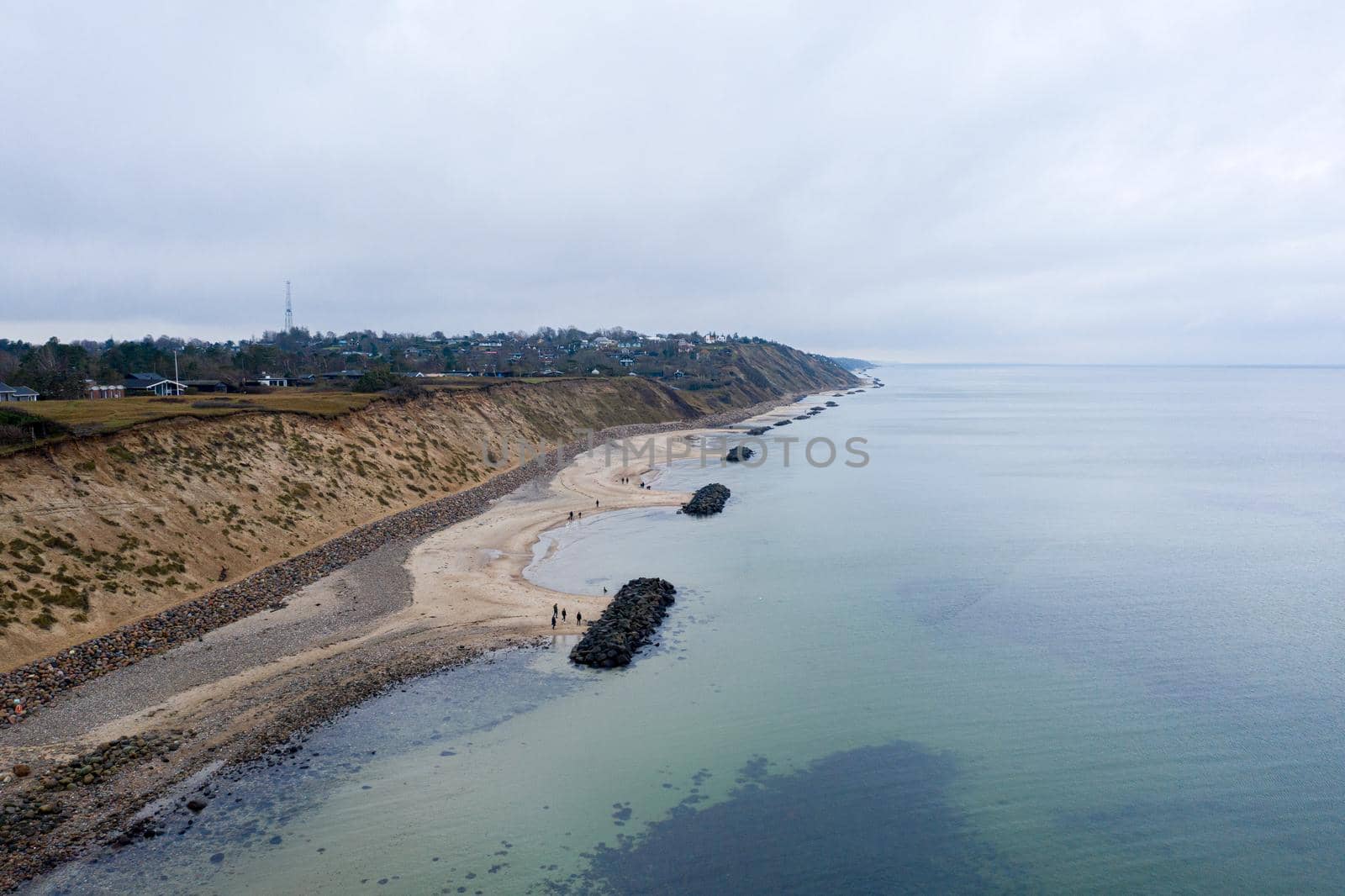 Vejby, Denmark - January 1, 2021: Aerial drone view of the coastline with breakwaters at Vejby Beach.