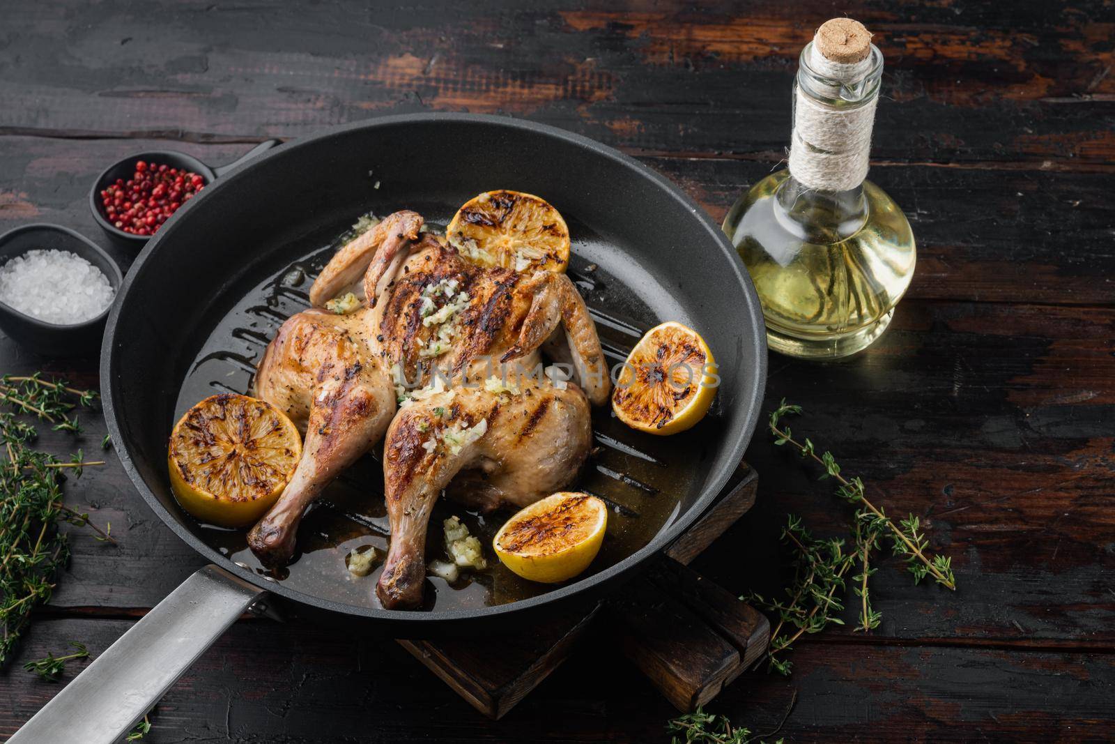Spatchcocked chicken and herbs, on old wooden table