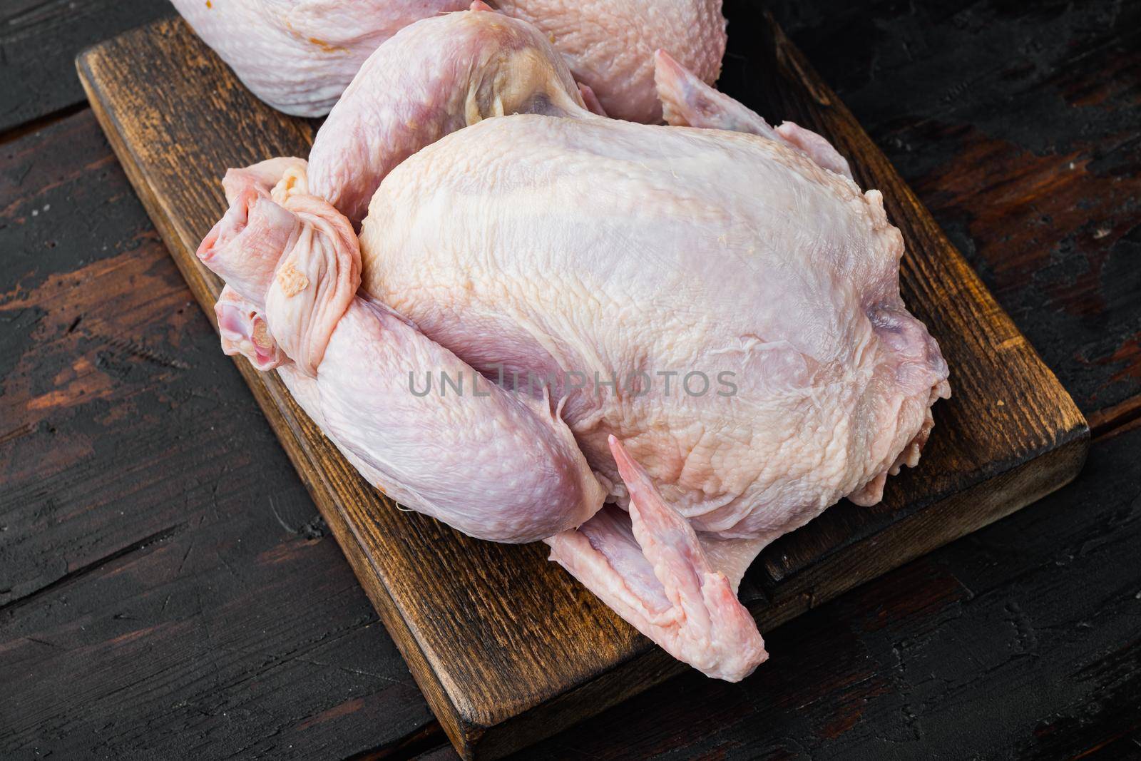Raw small young whole chicken, on old wooden table