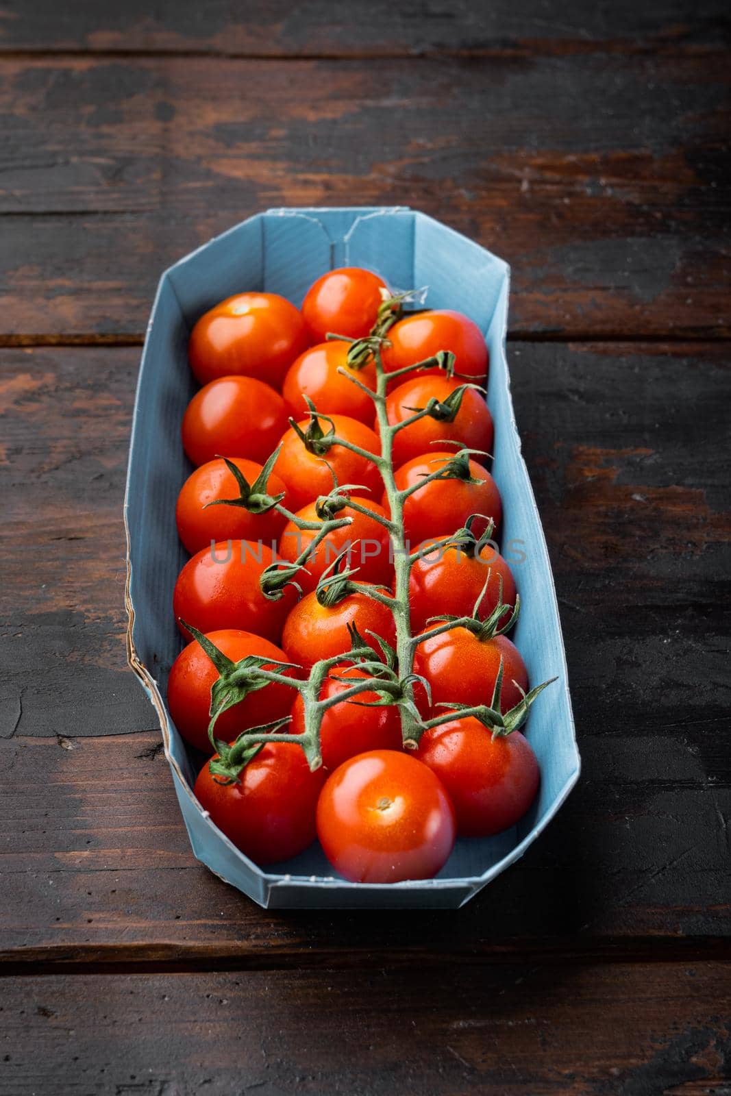 Red small cherry tomatoes, on dark wooden background