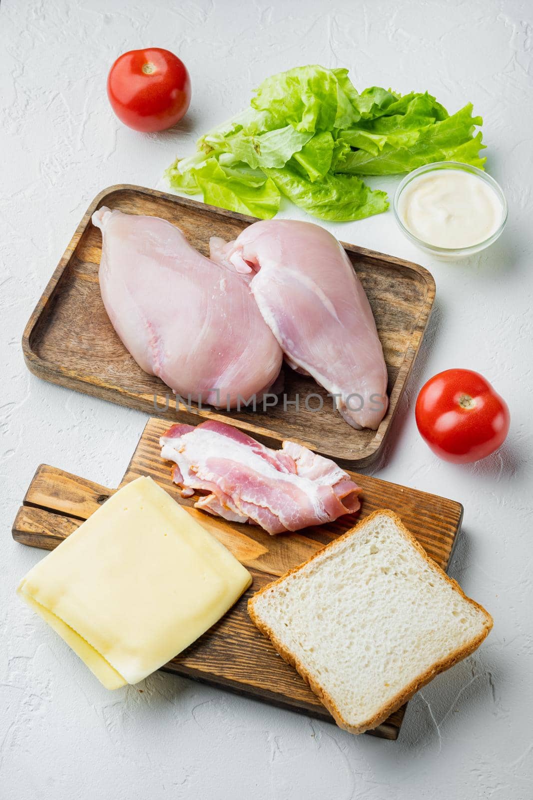 Ingredients for sandwich, bacon, cheese, tomato, chicken meat, lettuce, sauce, on white background