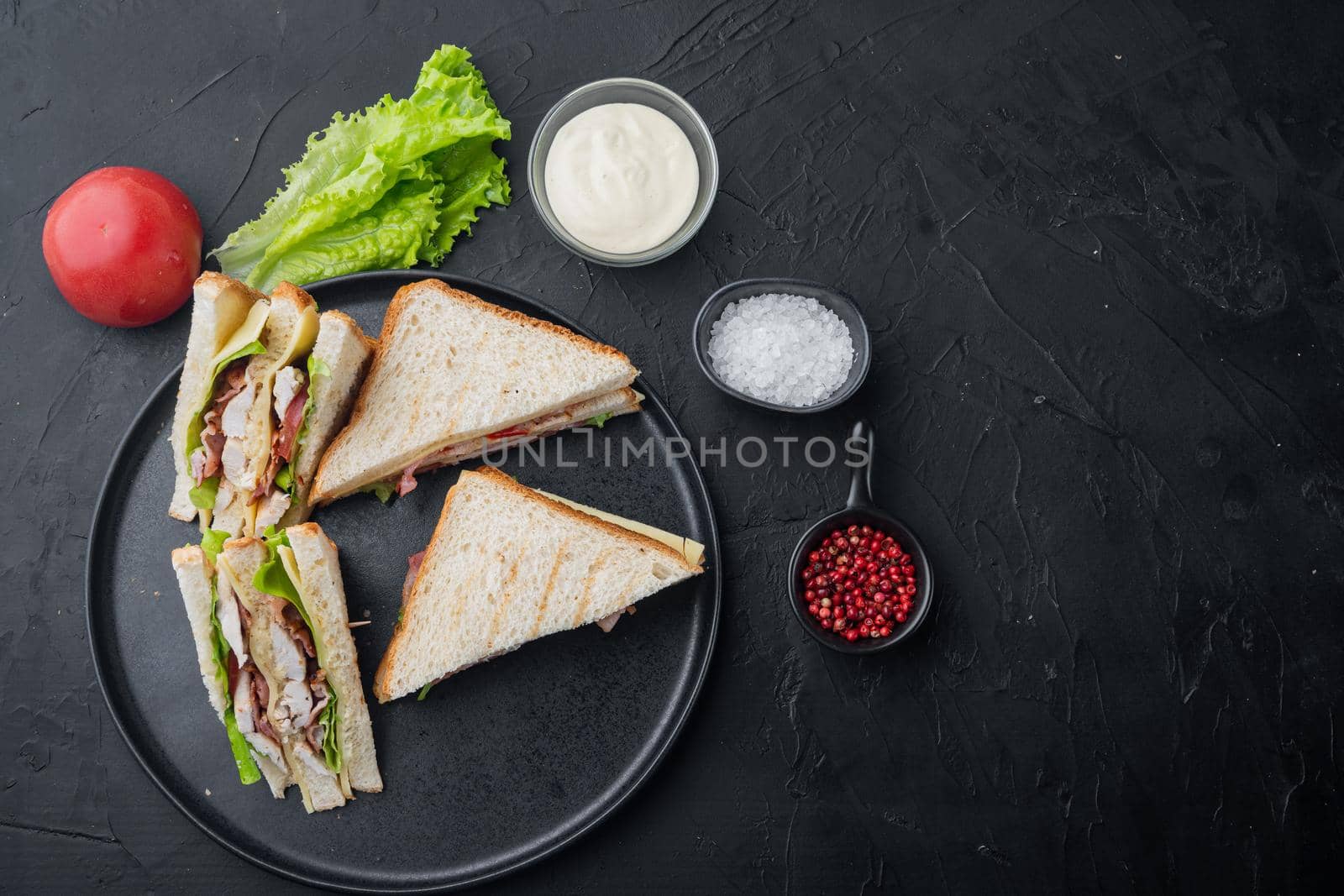 Classic club sandwich with meat, on black background, top view with copy space for text
