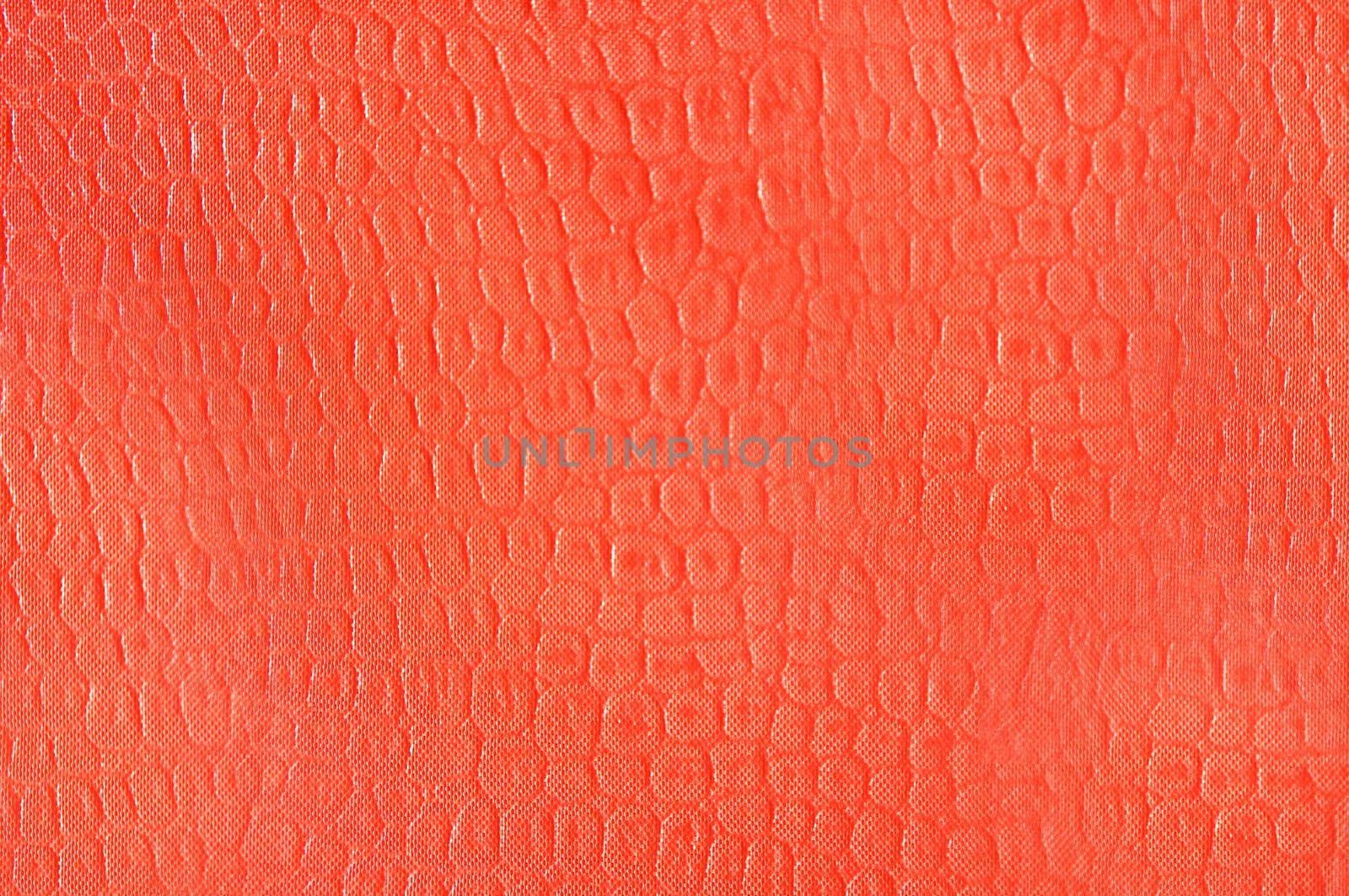 Artificial leather imitation crocodile skin in orange color.Texture or background