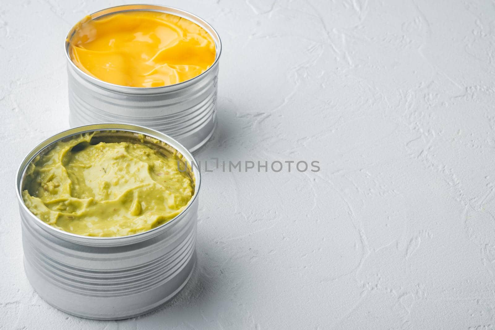 Canned guacamole and cheese dip in can, on white background with copy space for text
