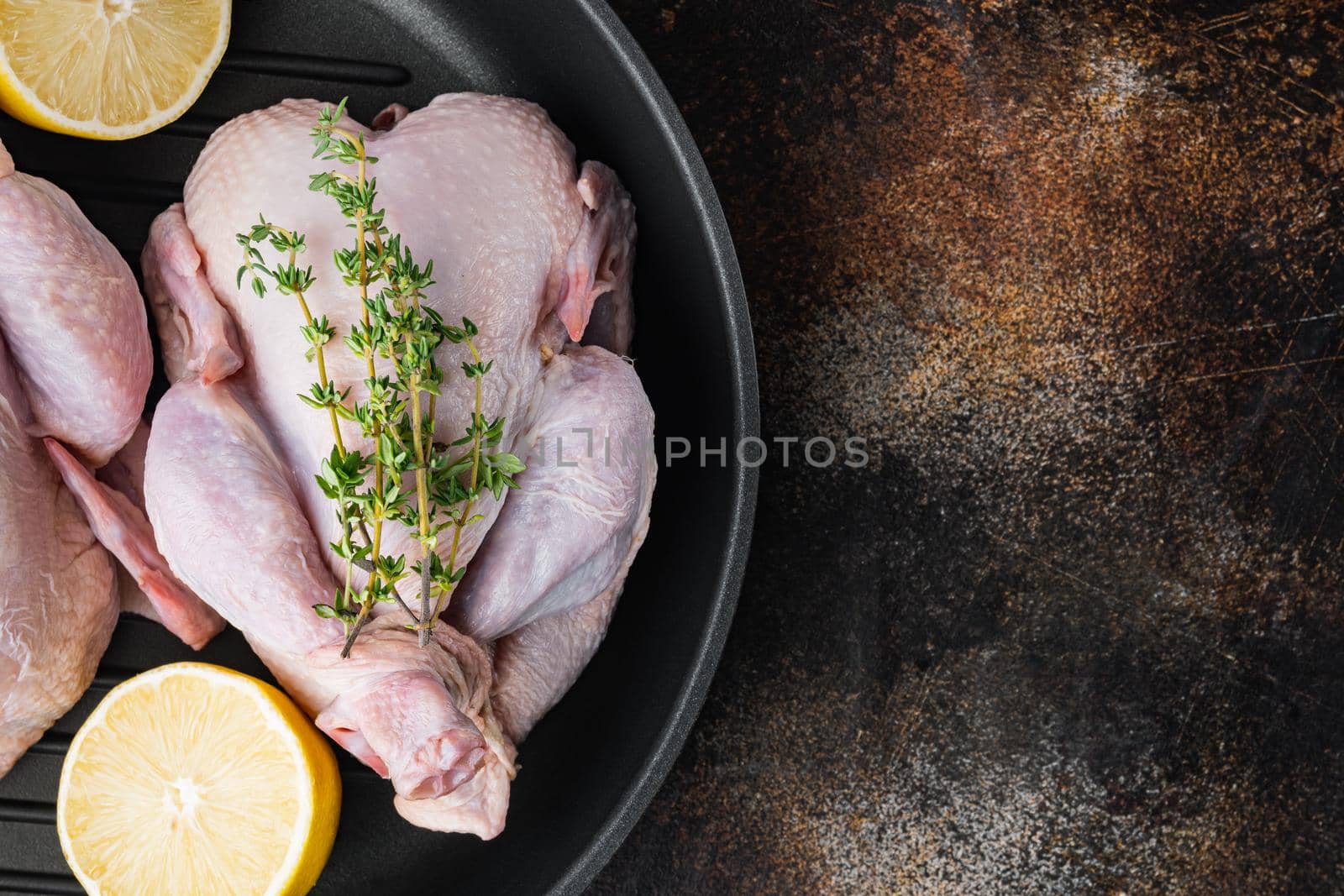 Whole raw free range fresh chicken on grill pan, on old rustic background, top view with copy space for text