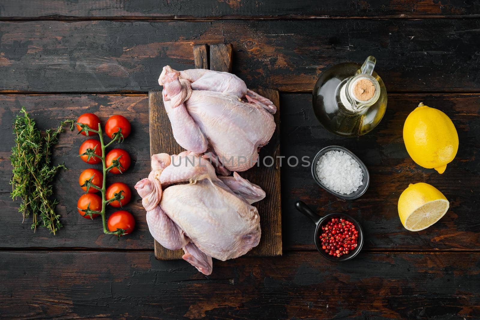 Whole raw free range fresh chicken with ingredients, on old wooden table, top view