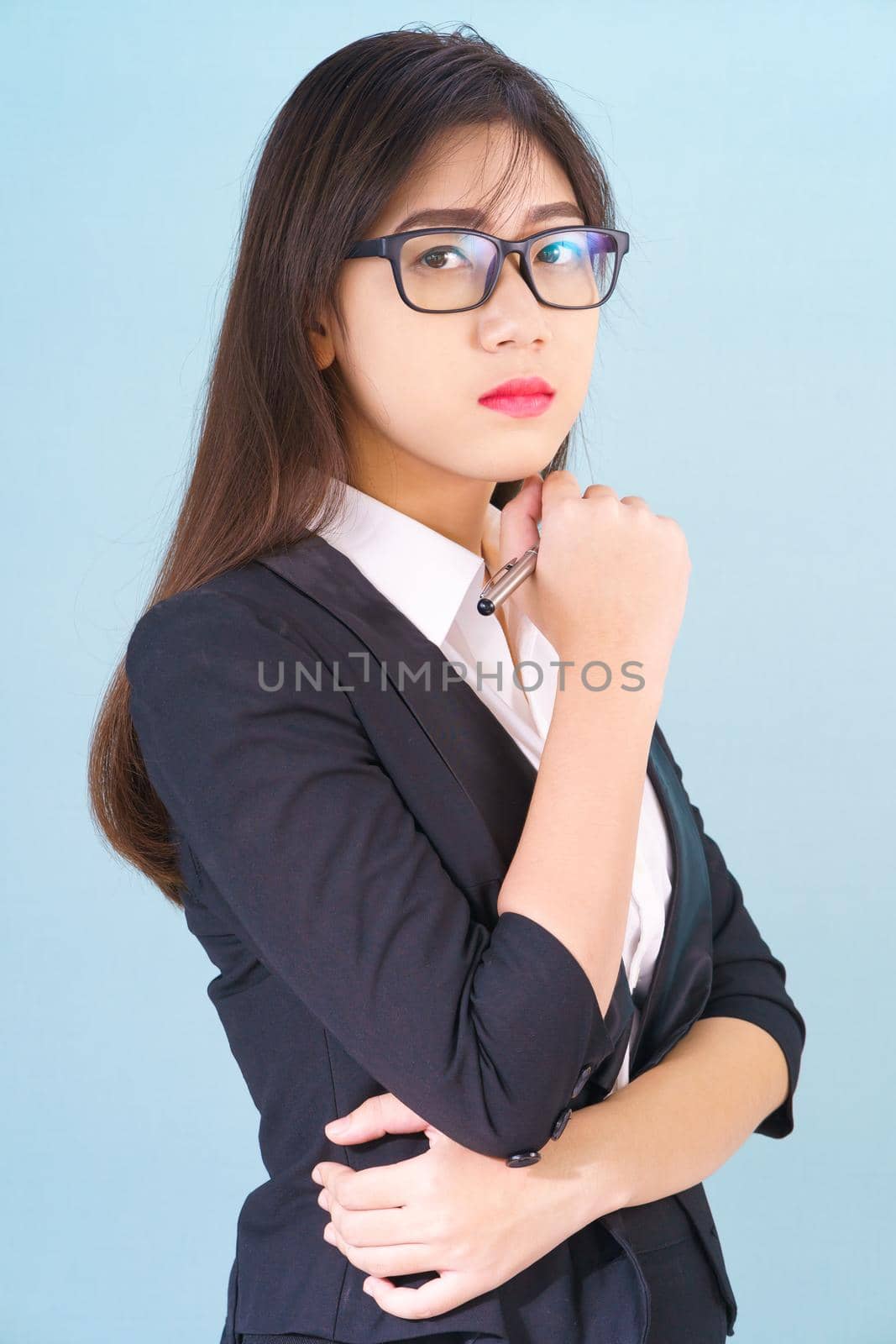 Young asian girl wearing suit with support hand on chin by stoonn