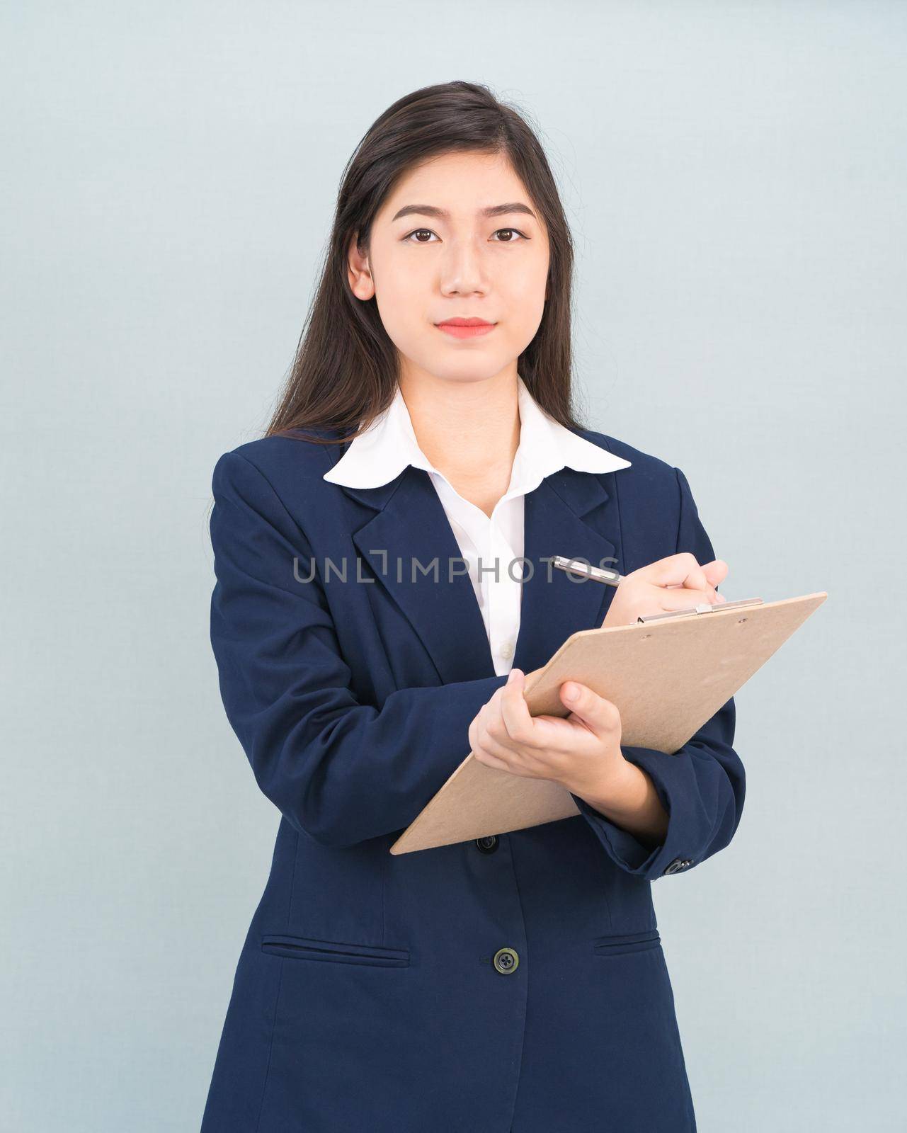 Portrait of Asian woman long hair and wearing suit  with clipboard and pen in hands thinking about success, isolated on white background