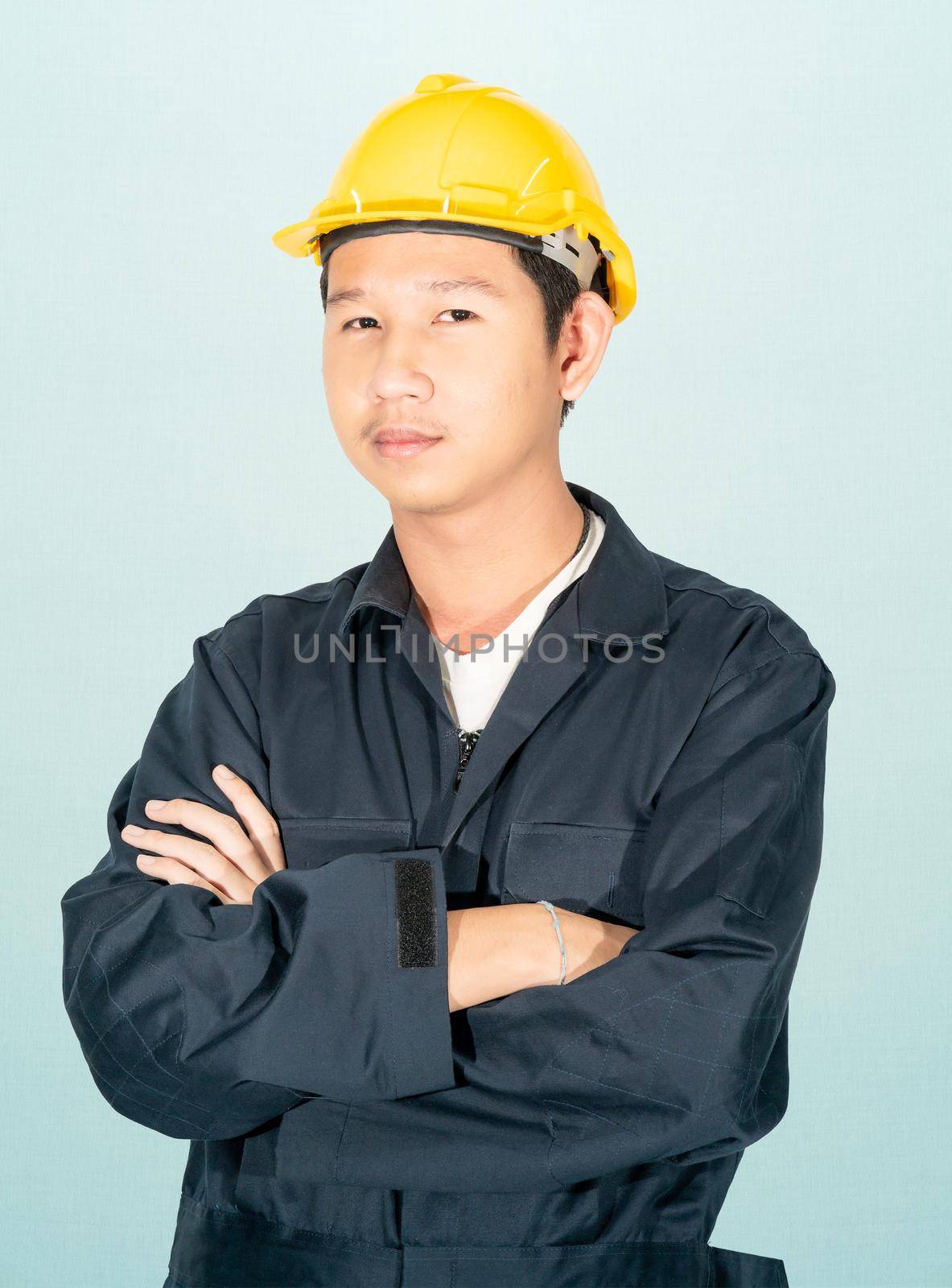 Young man in coveralls helmet hardhat isolated on blue background