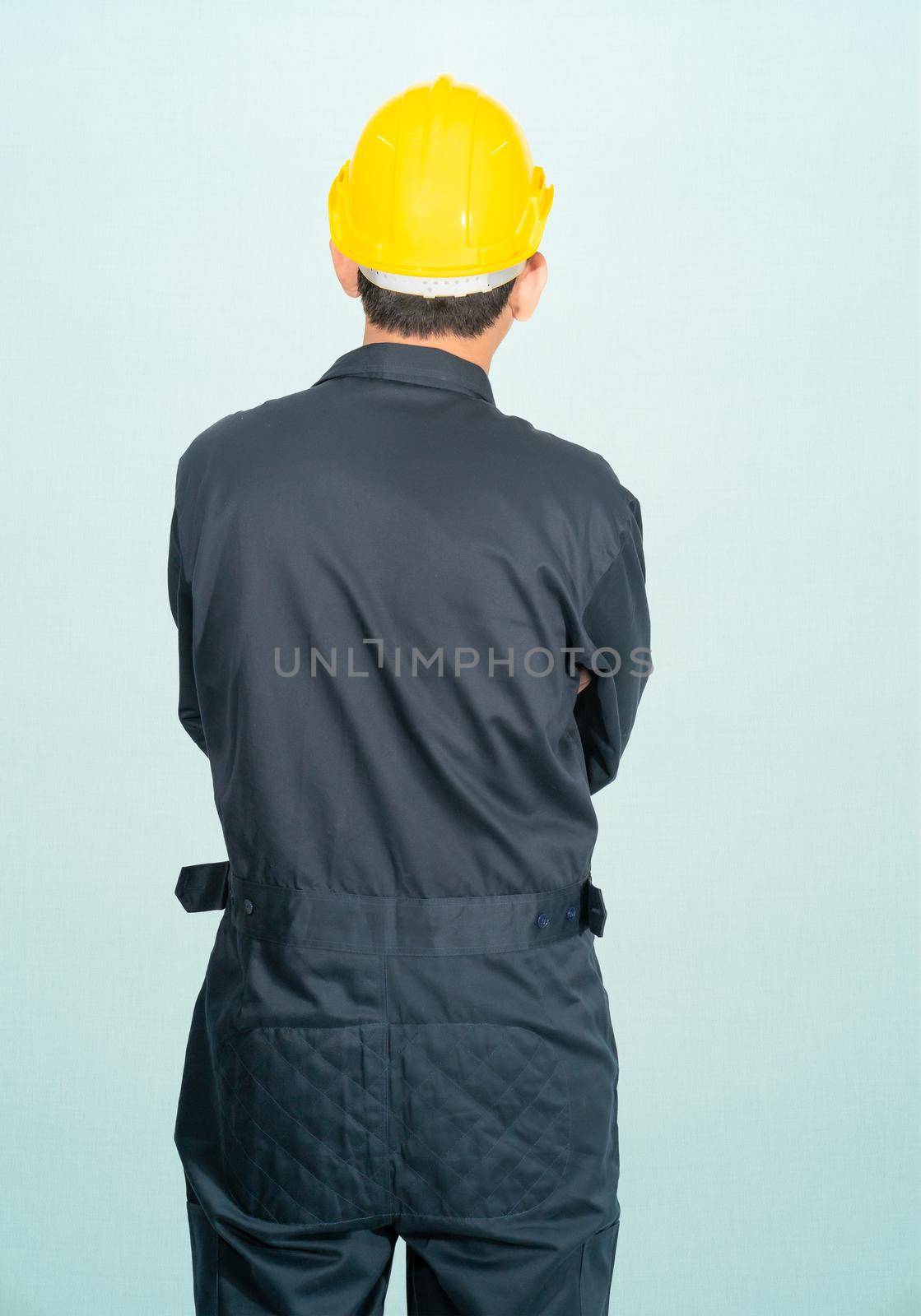 Young man in coveralls helmet hardhat isolated on blue background