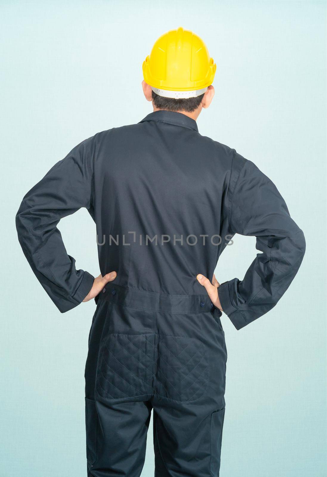 Young man in coveralls helmet hardhat isolated on blue background