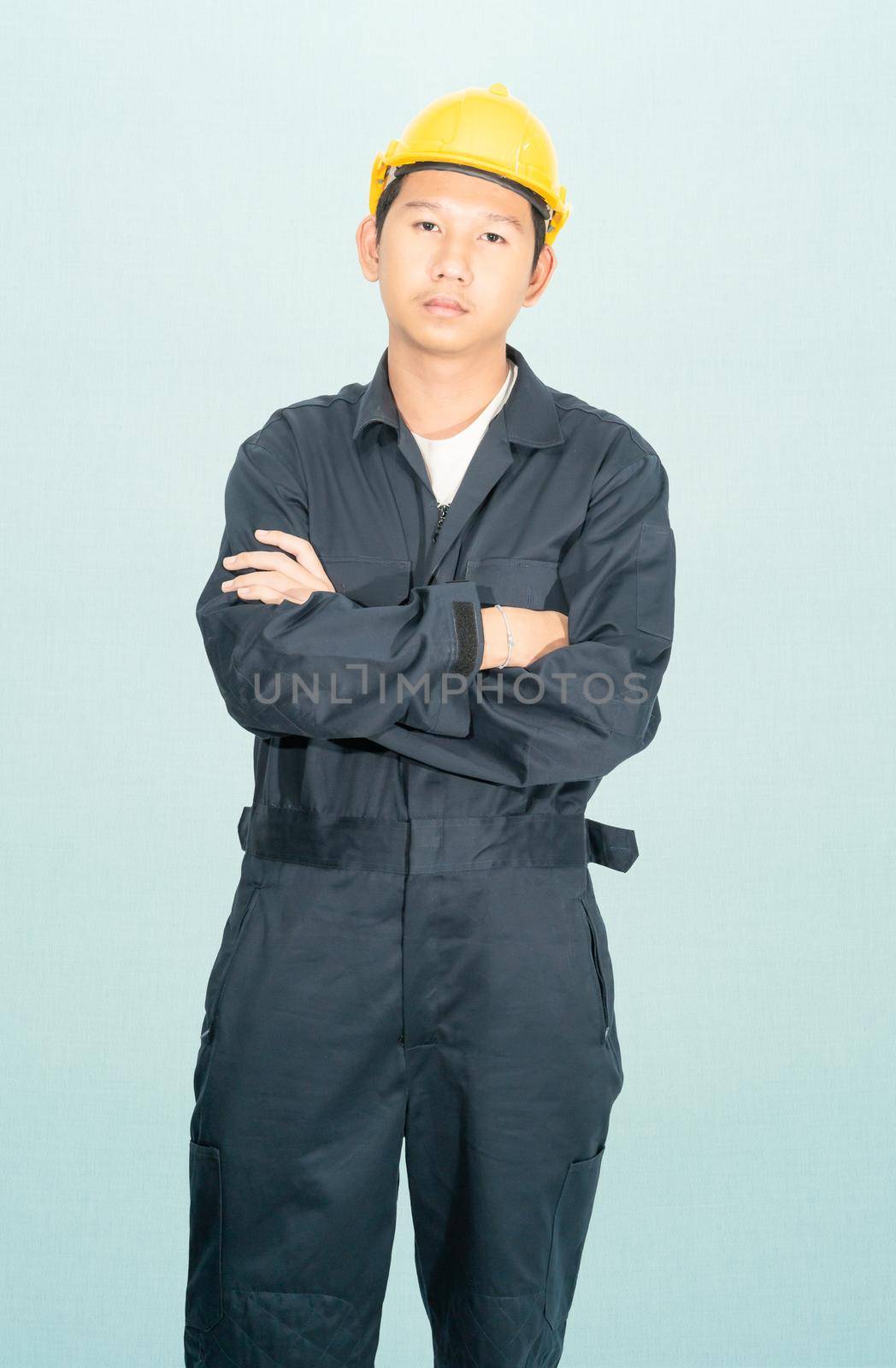 Young man in coveralls helmet hardhat isolated on blue background