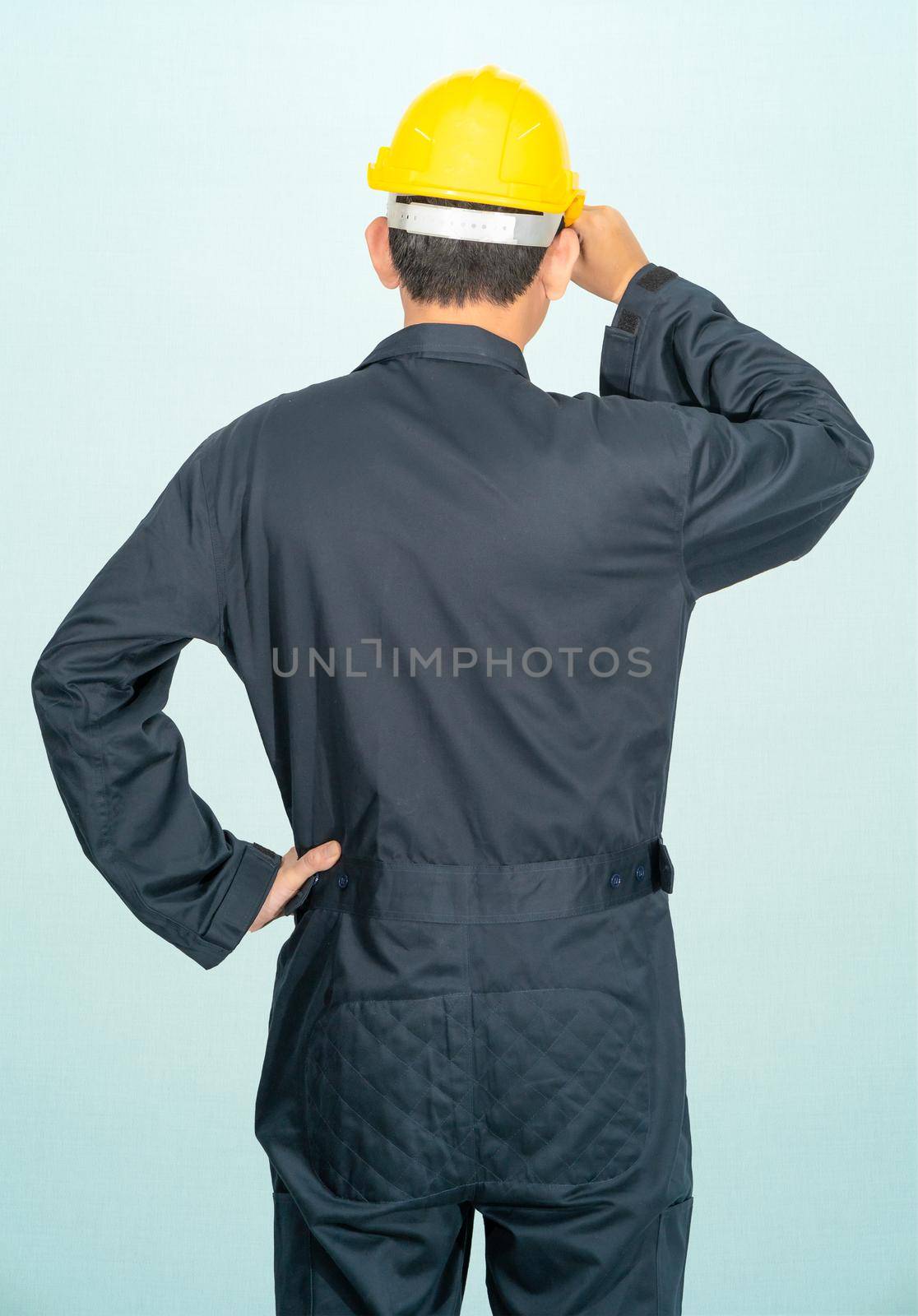 Young man in coveralls helmet hardhat isolated on blue background