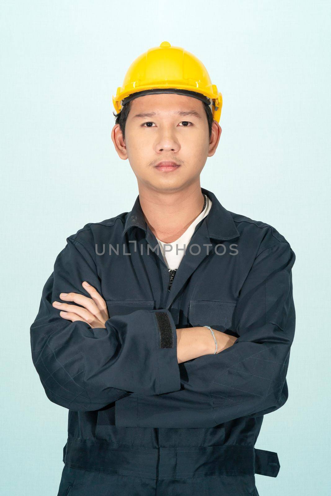 Young man in coveralls helmet hardhat isolated on blue background