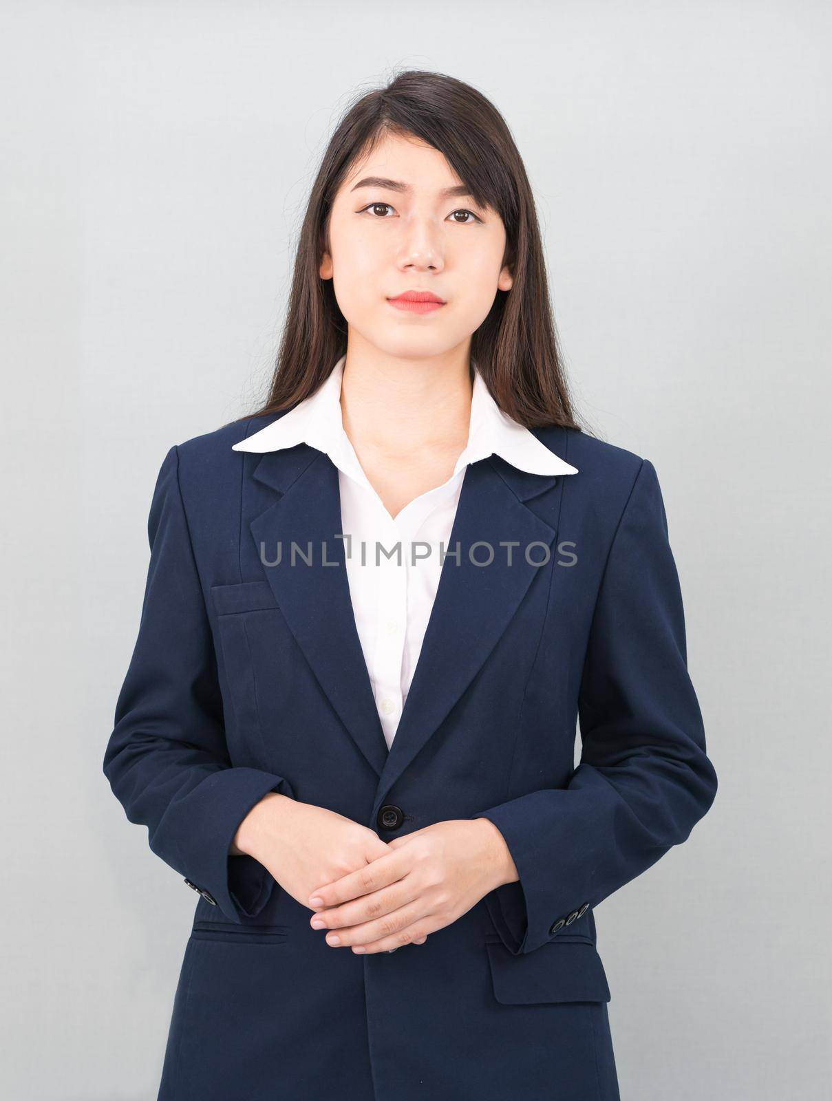 Portrait of asian business woman standing isolated on gray background