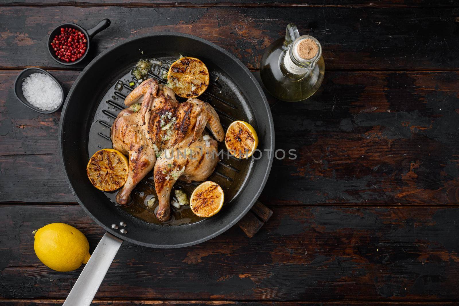 Flattened out whole baked chicken set, on old wooden table, top view with copy space for text
