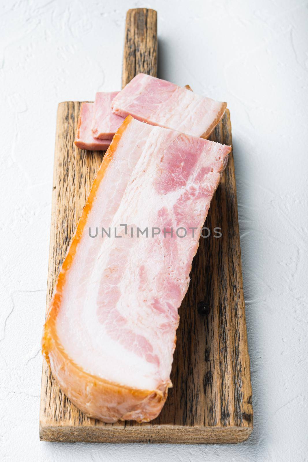 Smoked bacon, whole slab on white background.