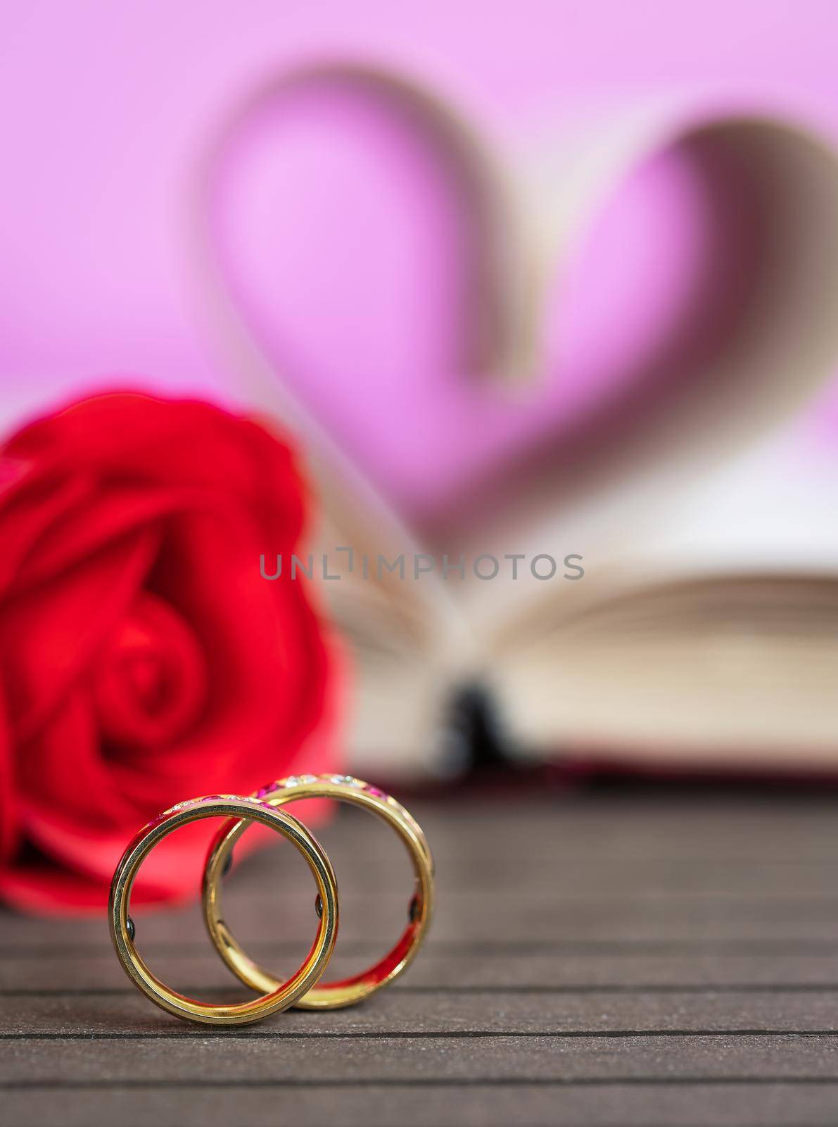 Wedding ring pages of book curved into a heart shape and red rose,Love concept of heart shape from book pages