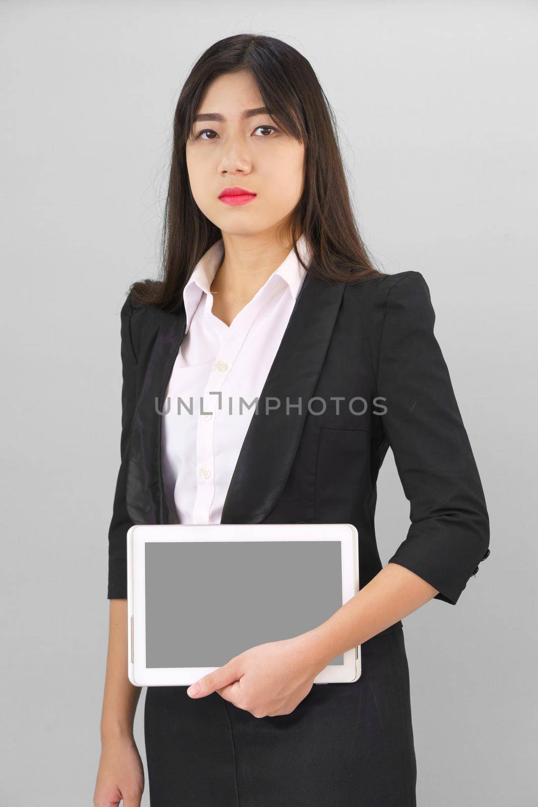 Young women standing in suit holding digital tablet by stoonn