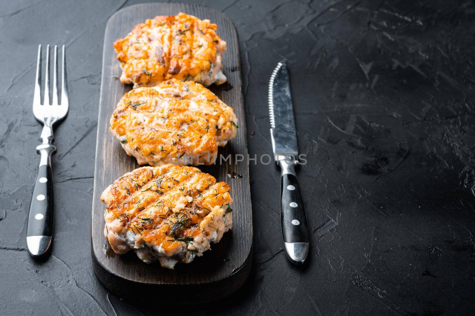 Grilled quick asian salmon cutlet, on black textured background with space for text