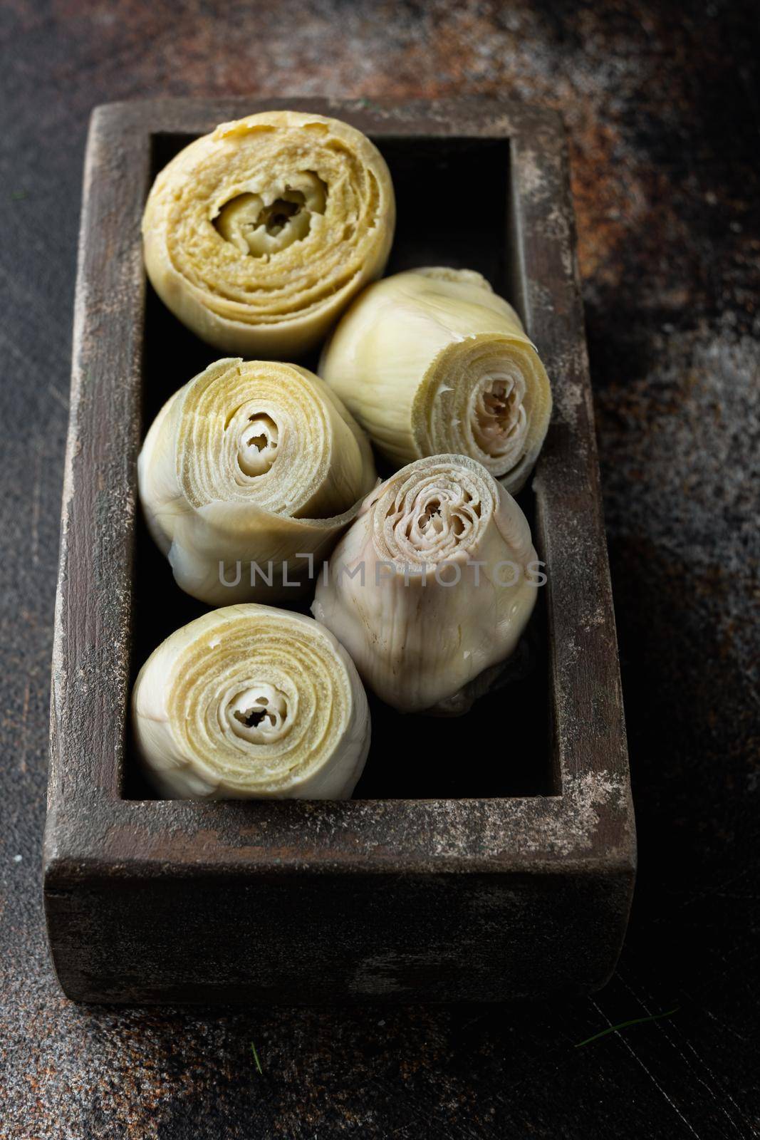 Canned artichokes with olive oil, on old rustic background