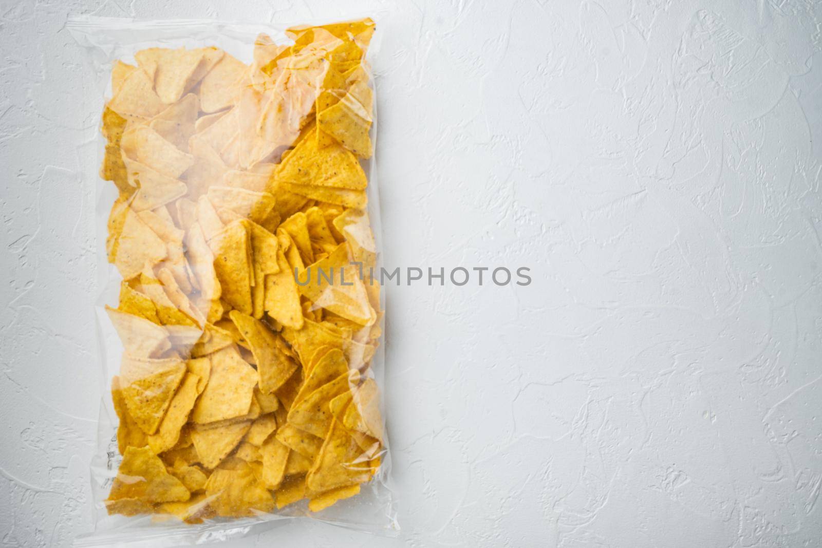 Nachos, corn tortilla in bag, on white background, top view or flat lay with copy space for text