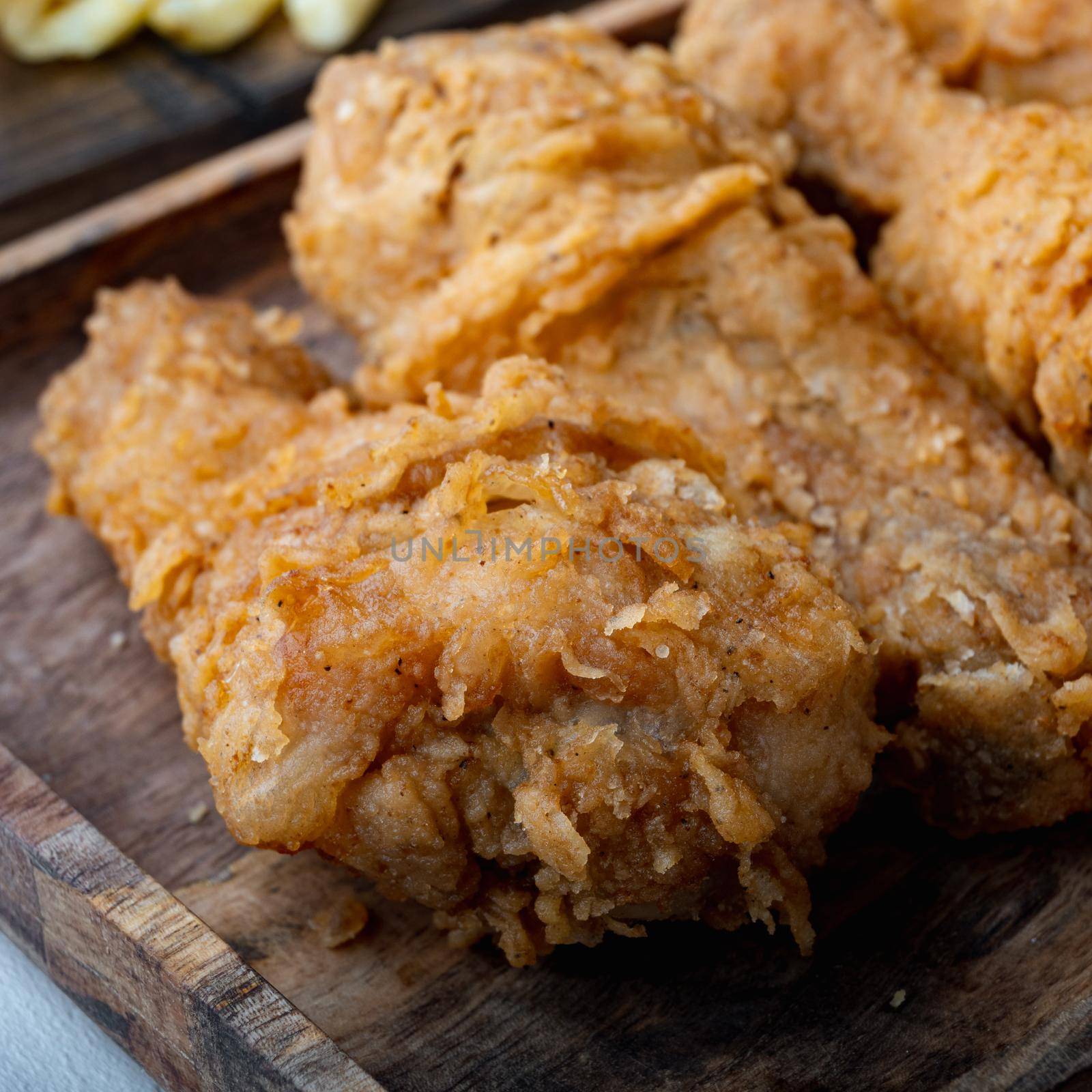 Fried crispy chicken legs, drumstick parts on grey background.