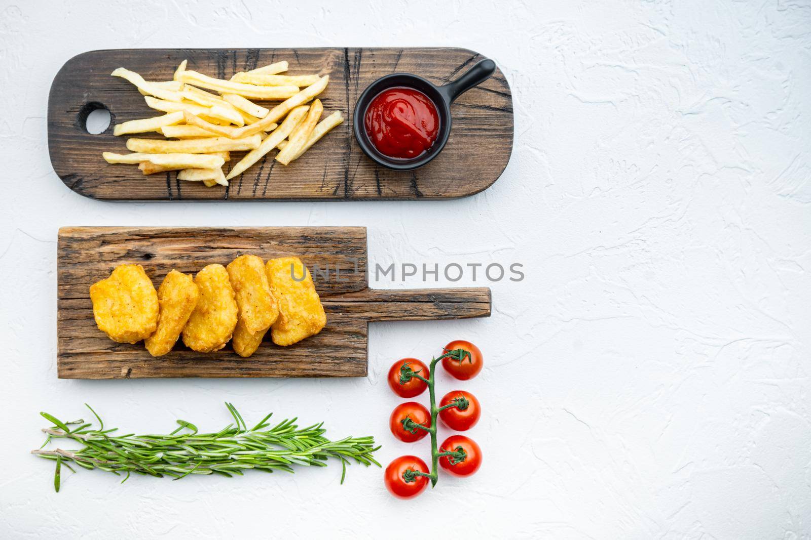 Chicken nuggets with fries on white background, top view, with copy space.