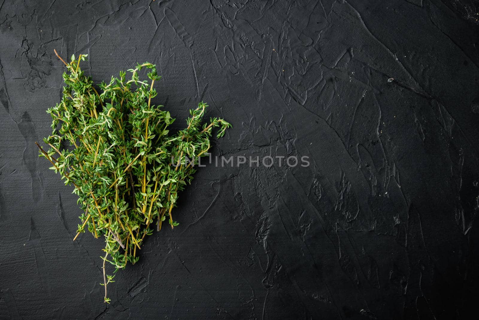 Thyme green fresh bunch, on black background, top view with copy space for text