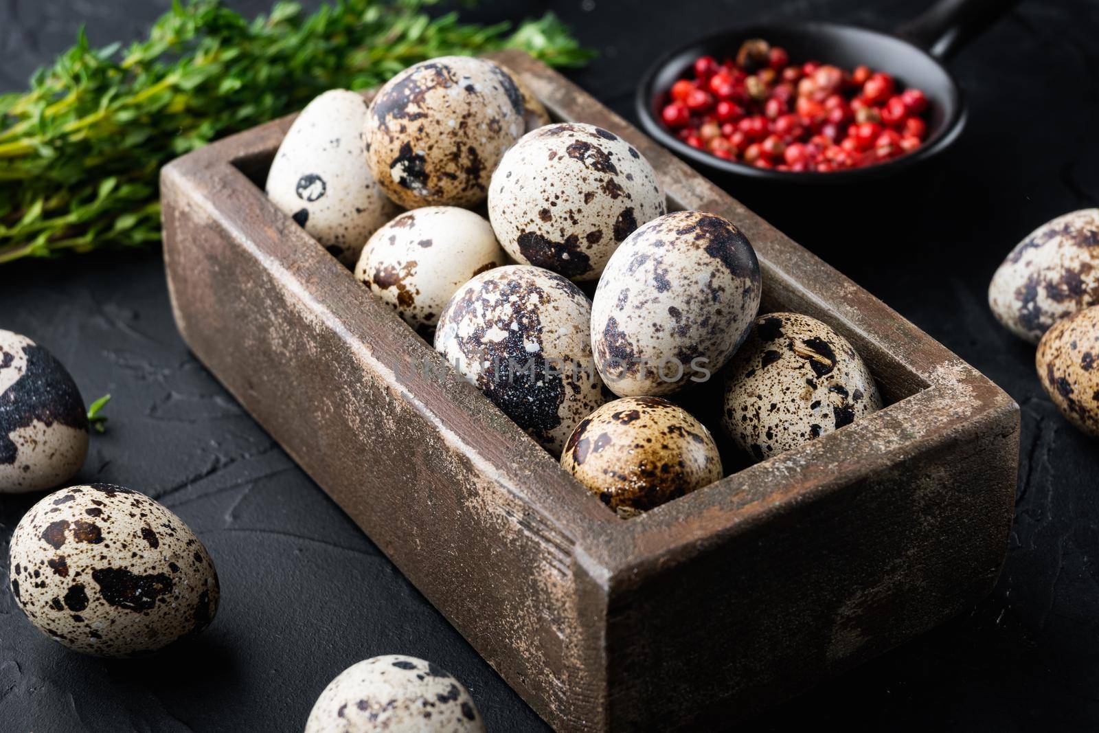 Fresh quails eggs, on black textured background