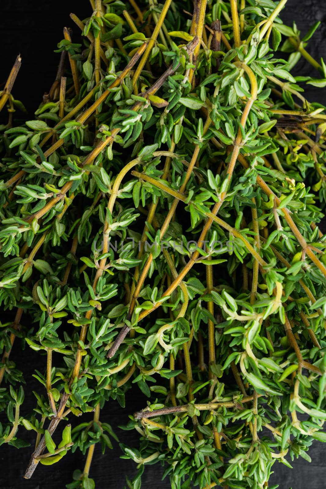 Thyme green fresh bunch, on black wooden background, top view