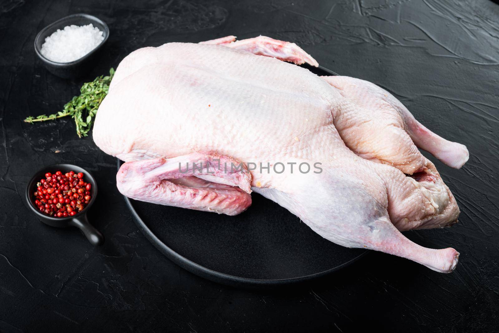 Whole raw duck meat on black background.
