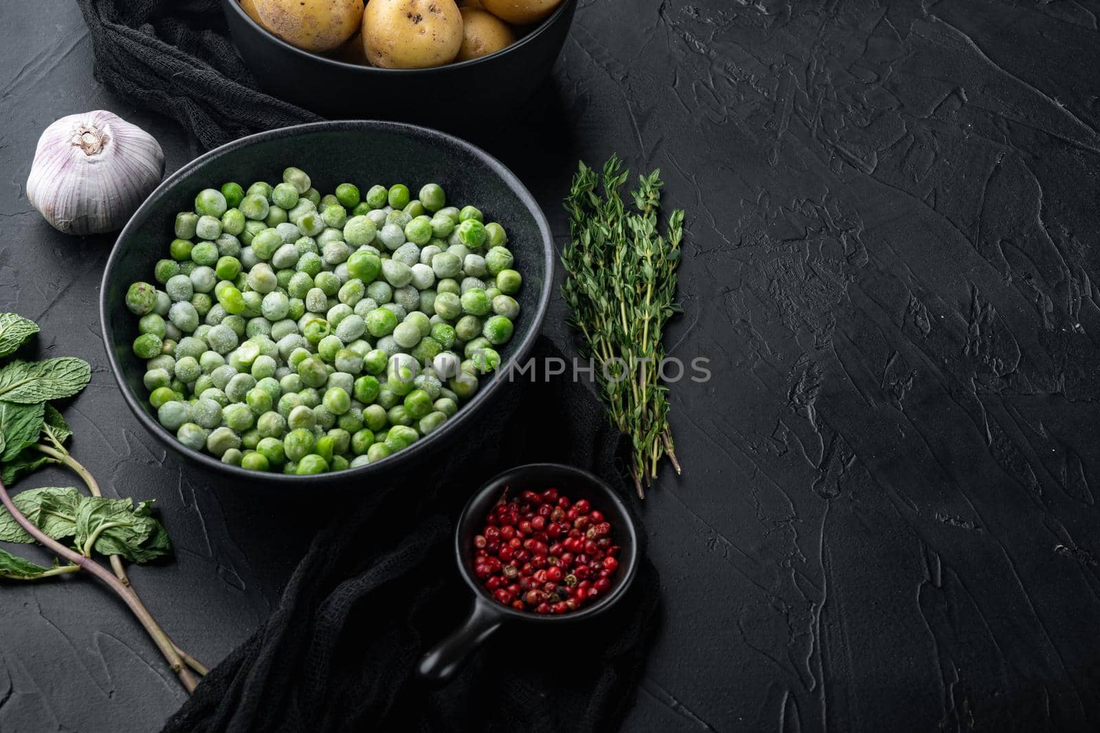 Green peas set, on black textured background with copy space