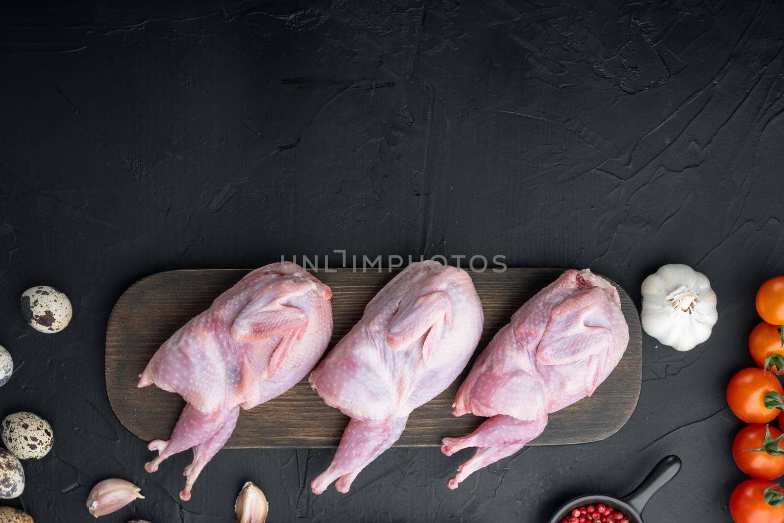Fresh raw meat quail ready for cooking, flat lay, on black textured background with space for text