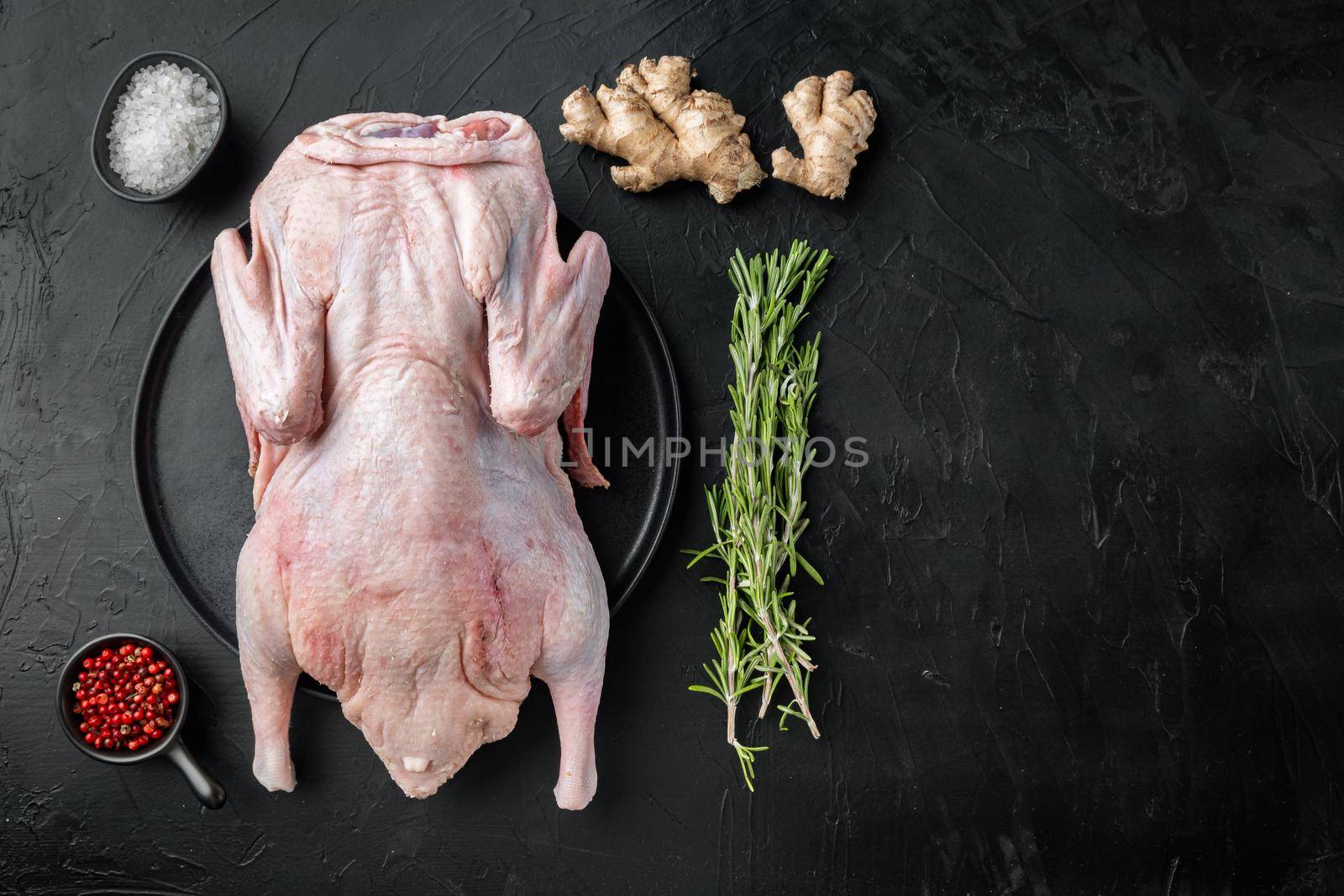Fresh raw whole duck meat on black background, top view, with copy space.