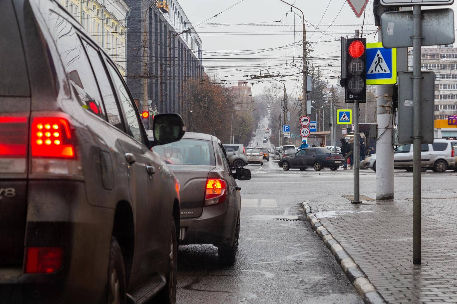 TULA, RUSSIA - NOVEMBER 21, 2020: Winter daytime street cars and pedestrians traffic at cross roads, view from ground.