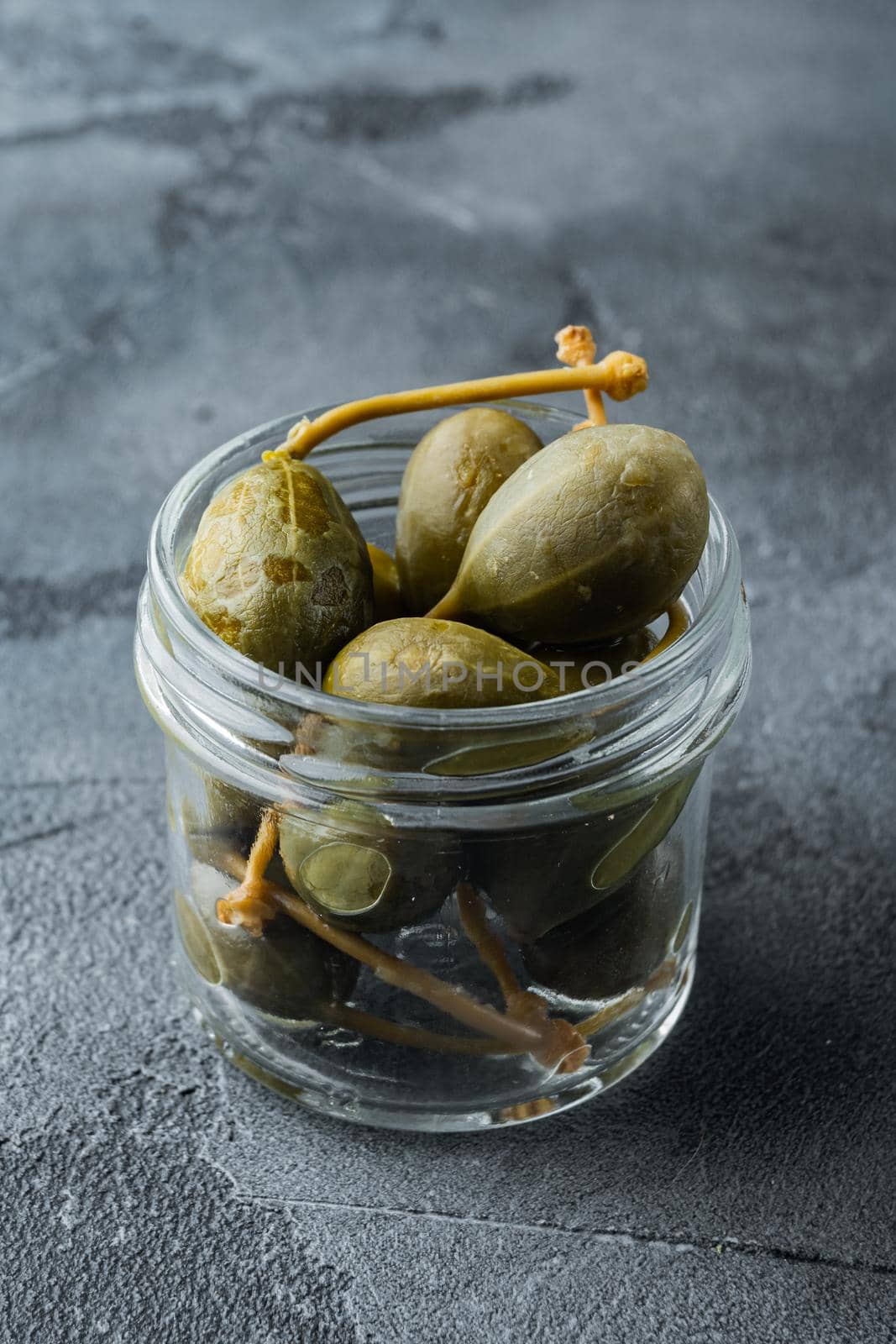 Organic pickled, canned capers, on gray background