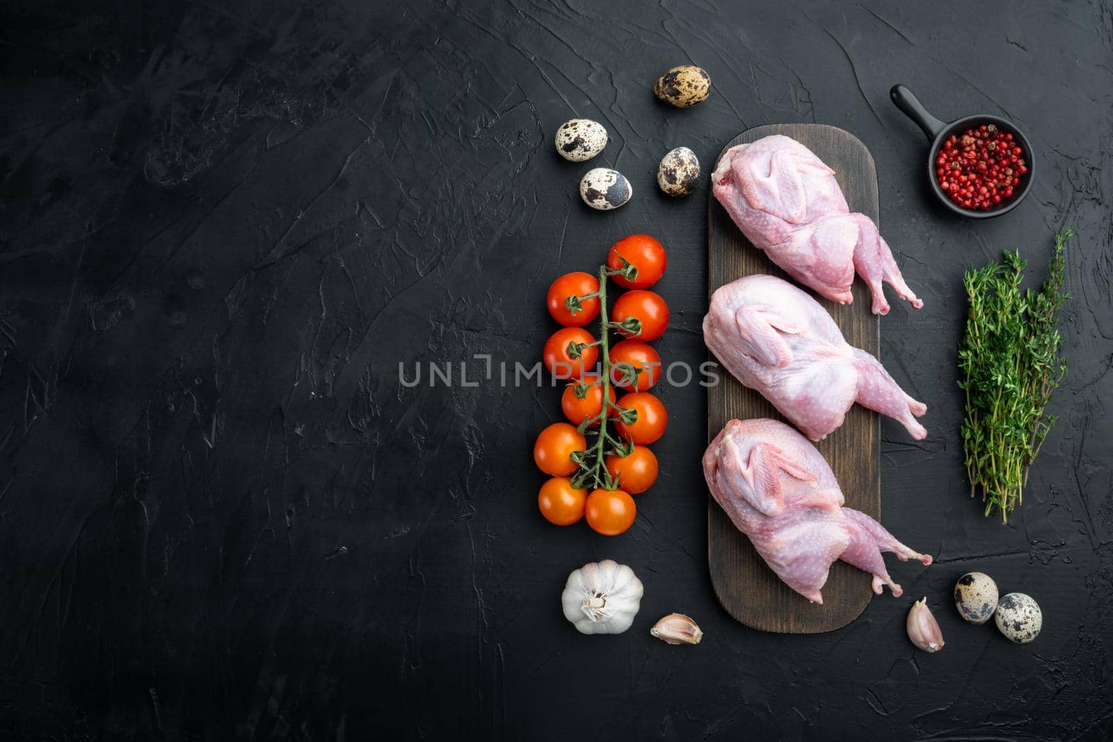 Fresh raw meat quail ready for cooking, flat lay, on black textured background with space for text