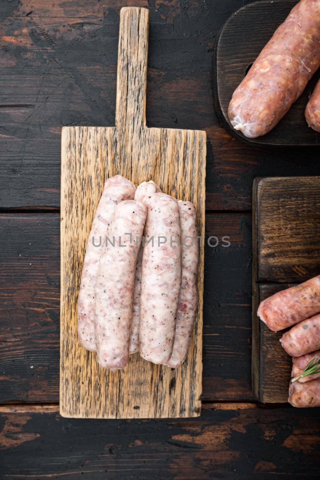 Homemade chicken meat sausages, top view, on old dark wooden background.