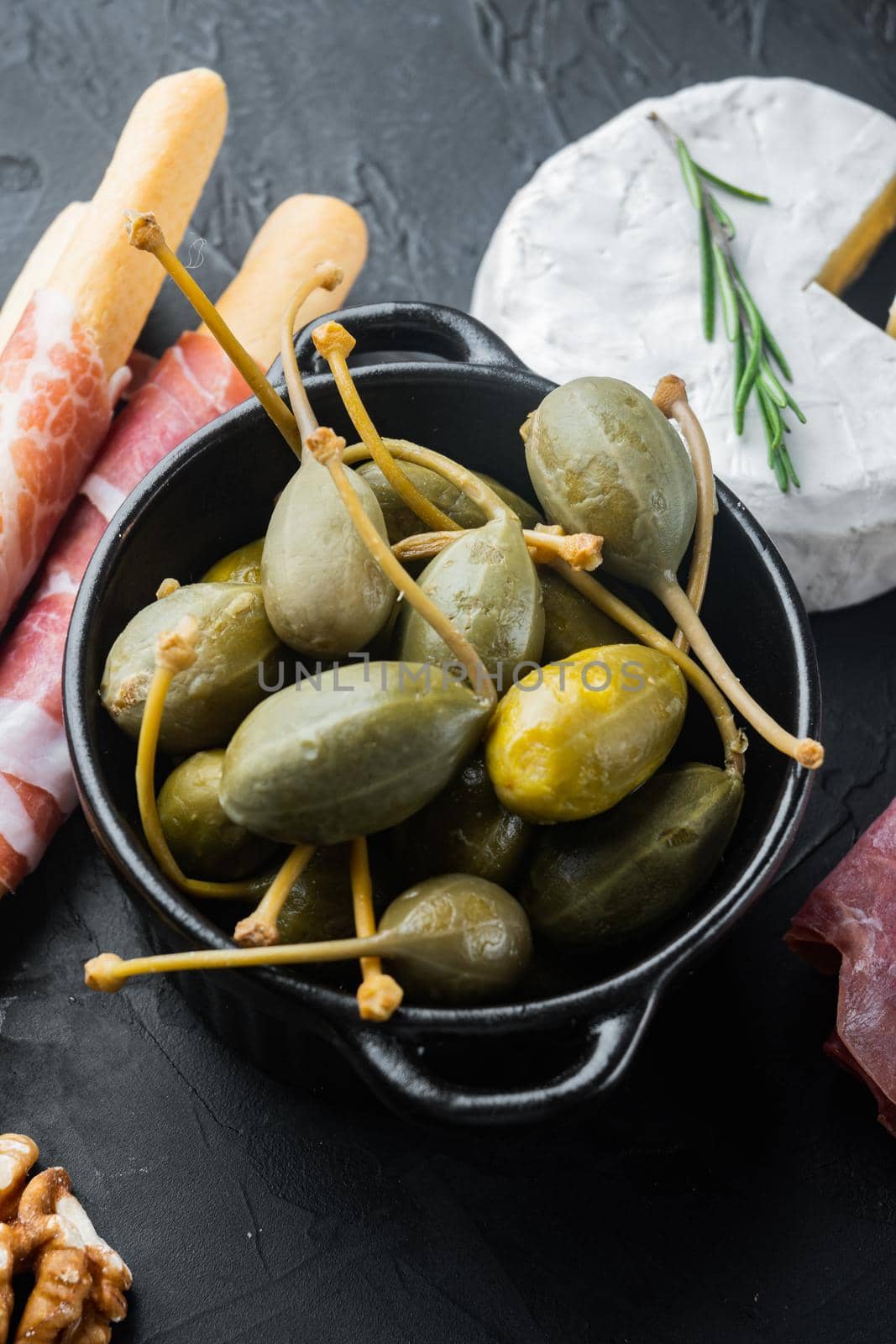 Organic pickled, canned capers, on black background