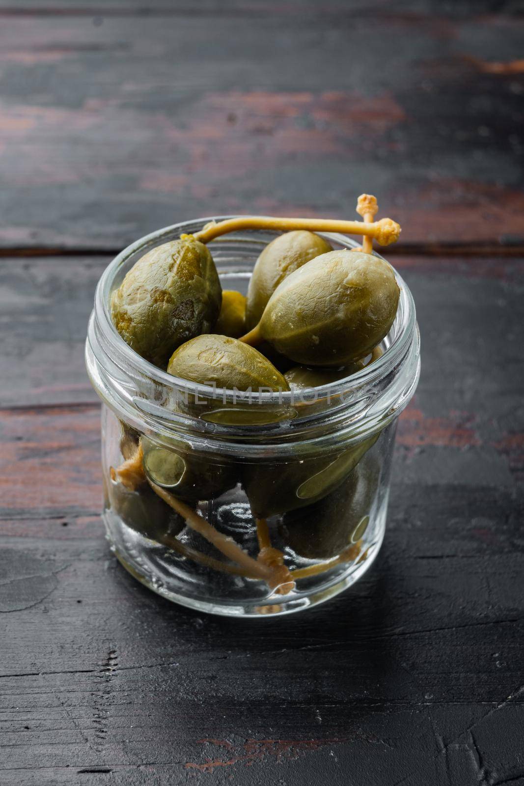 Organic pickled, canned capers, on old wooden table