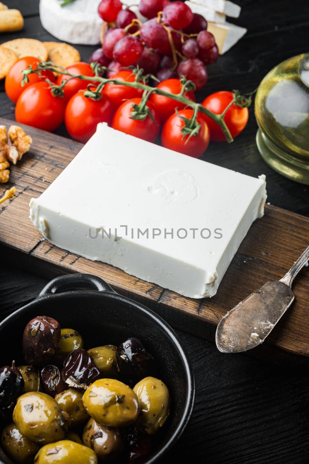 Ingredients for traditional greek salad set, on black wooden table