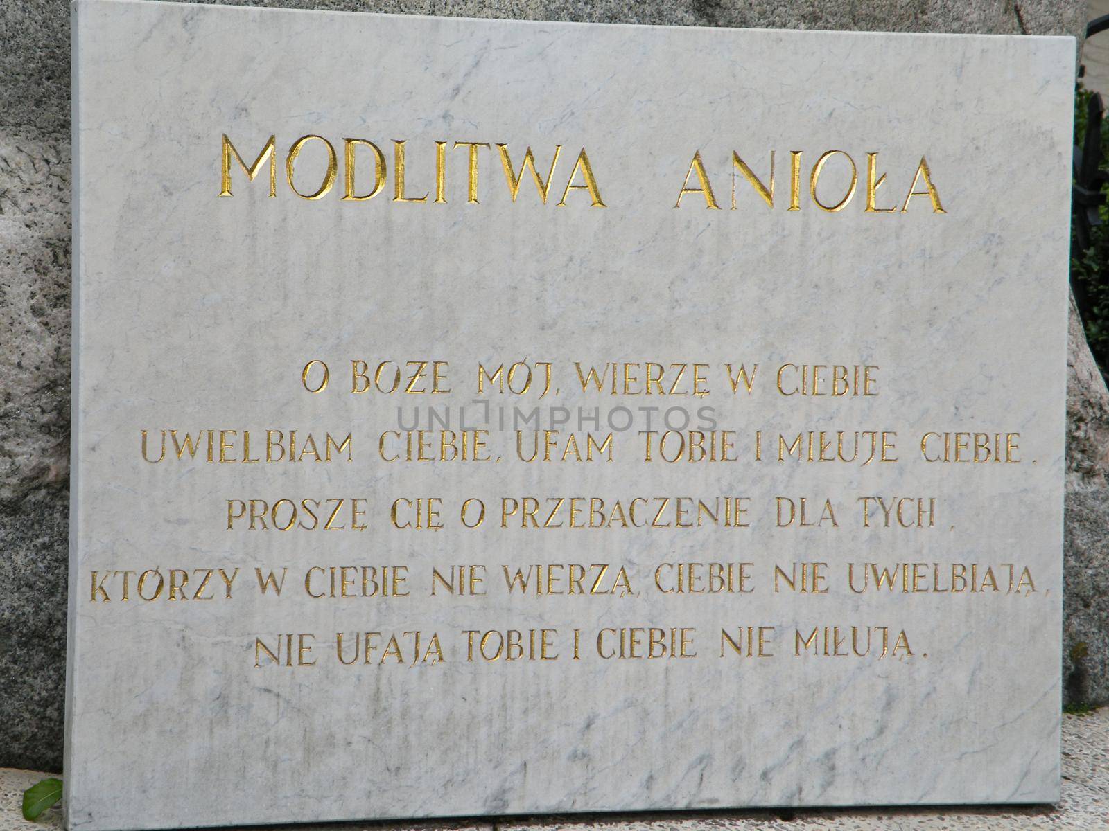 Engraved text of the Agel prayer on a marble tablet. Gold engraved text in Polish