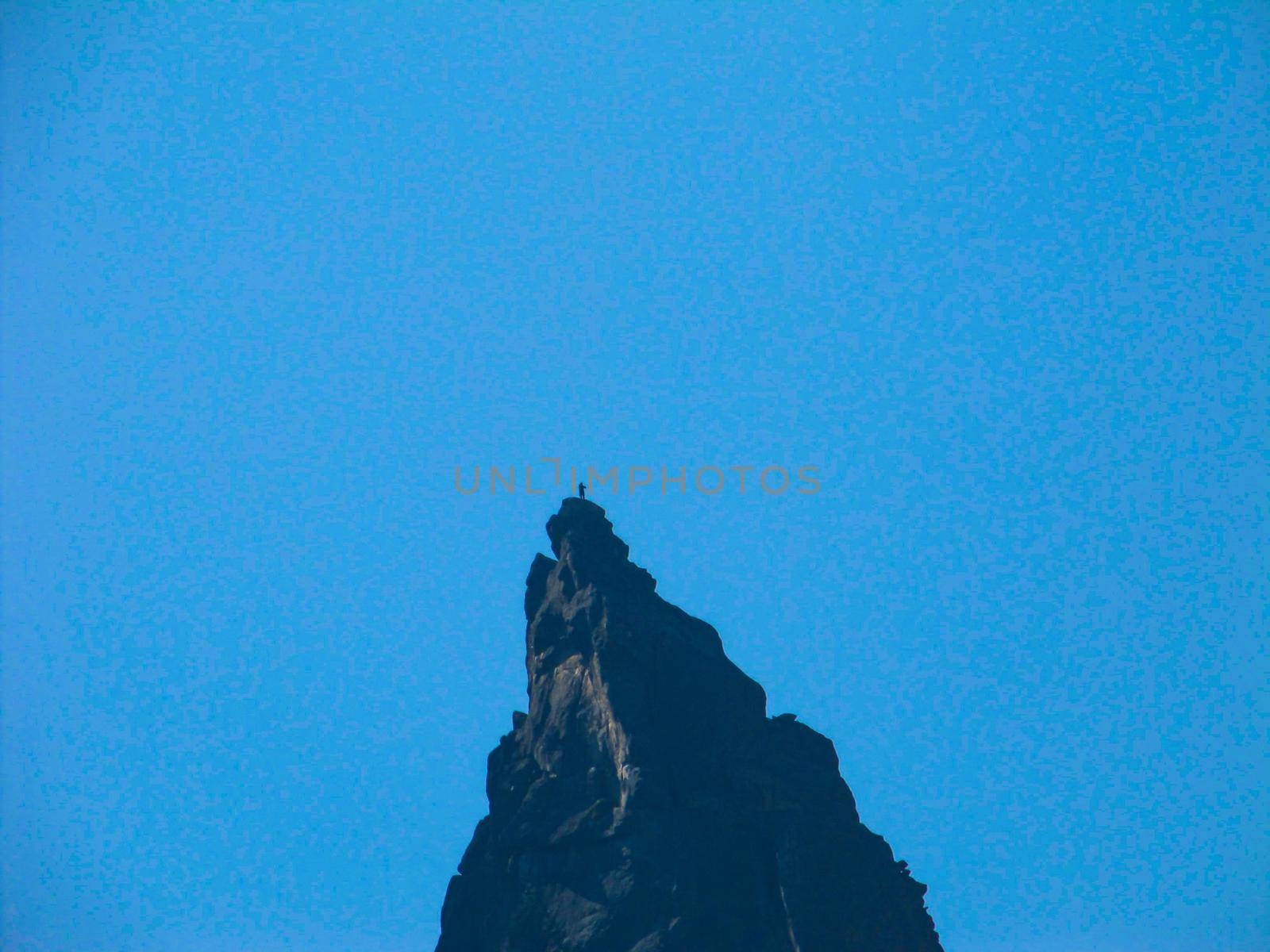 Man silhouette stay on a mountain top of the blue sky. by mtx
