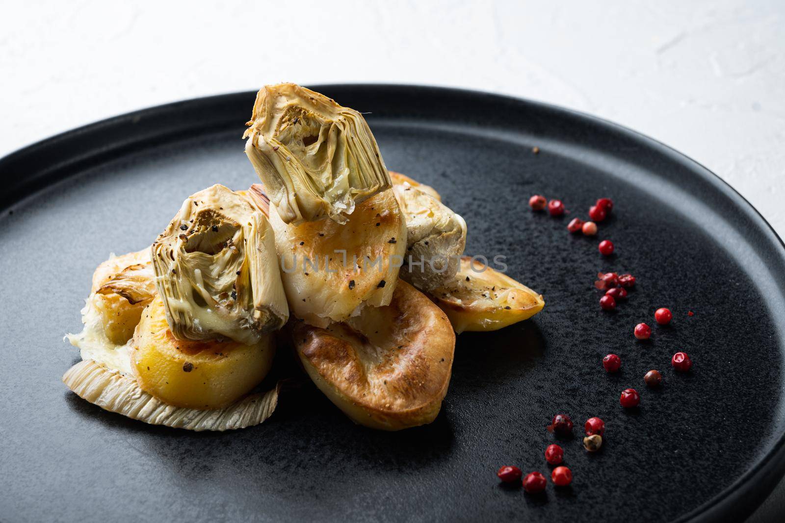 Baked potato, artichoke with fennel al forno, on white textured background